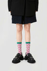 Pink socks from the 1+2 set, styled casually with a young woman's outfit