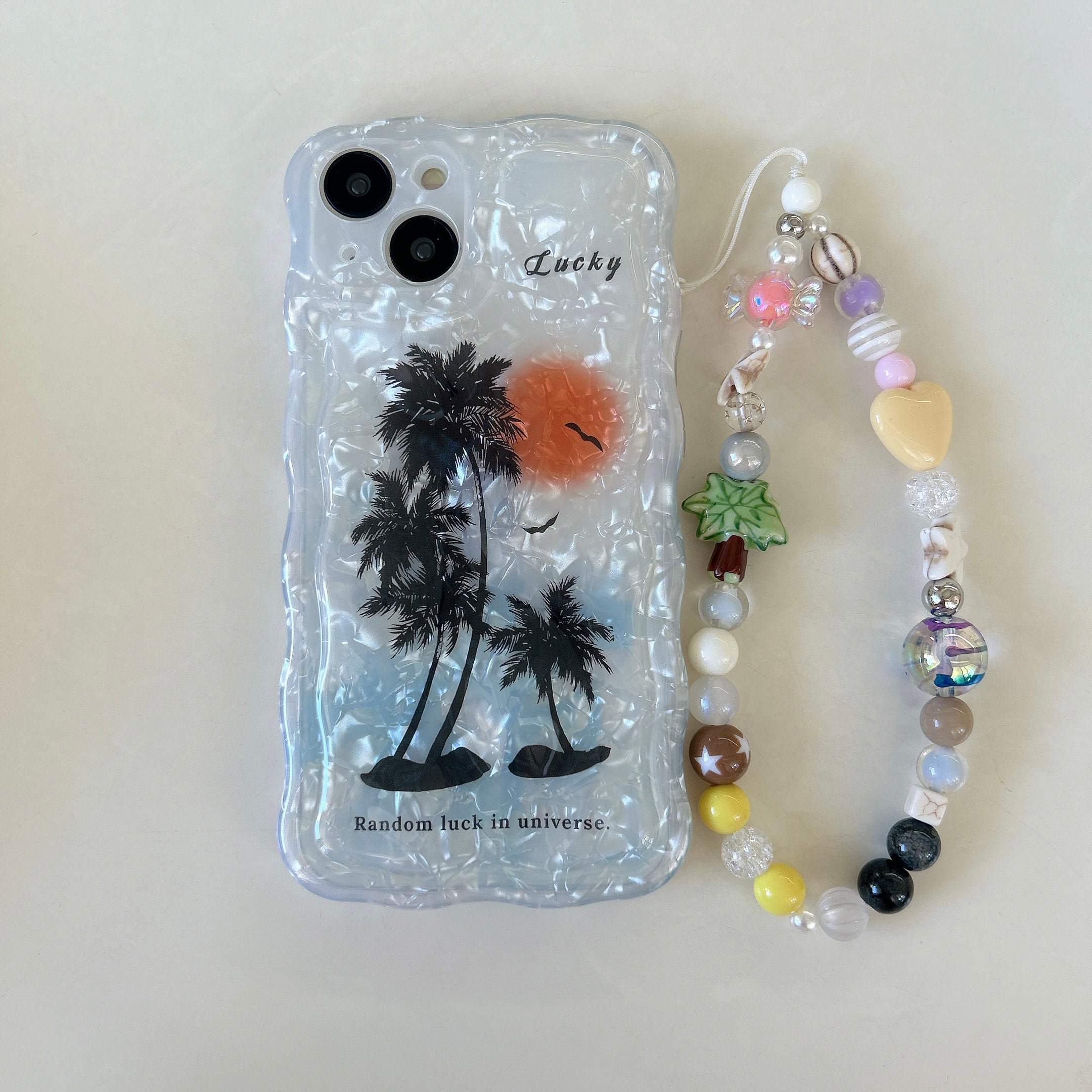 A stylish phone case with a coconut tree and phone chain compatible with iPhone 14 Pro Max