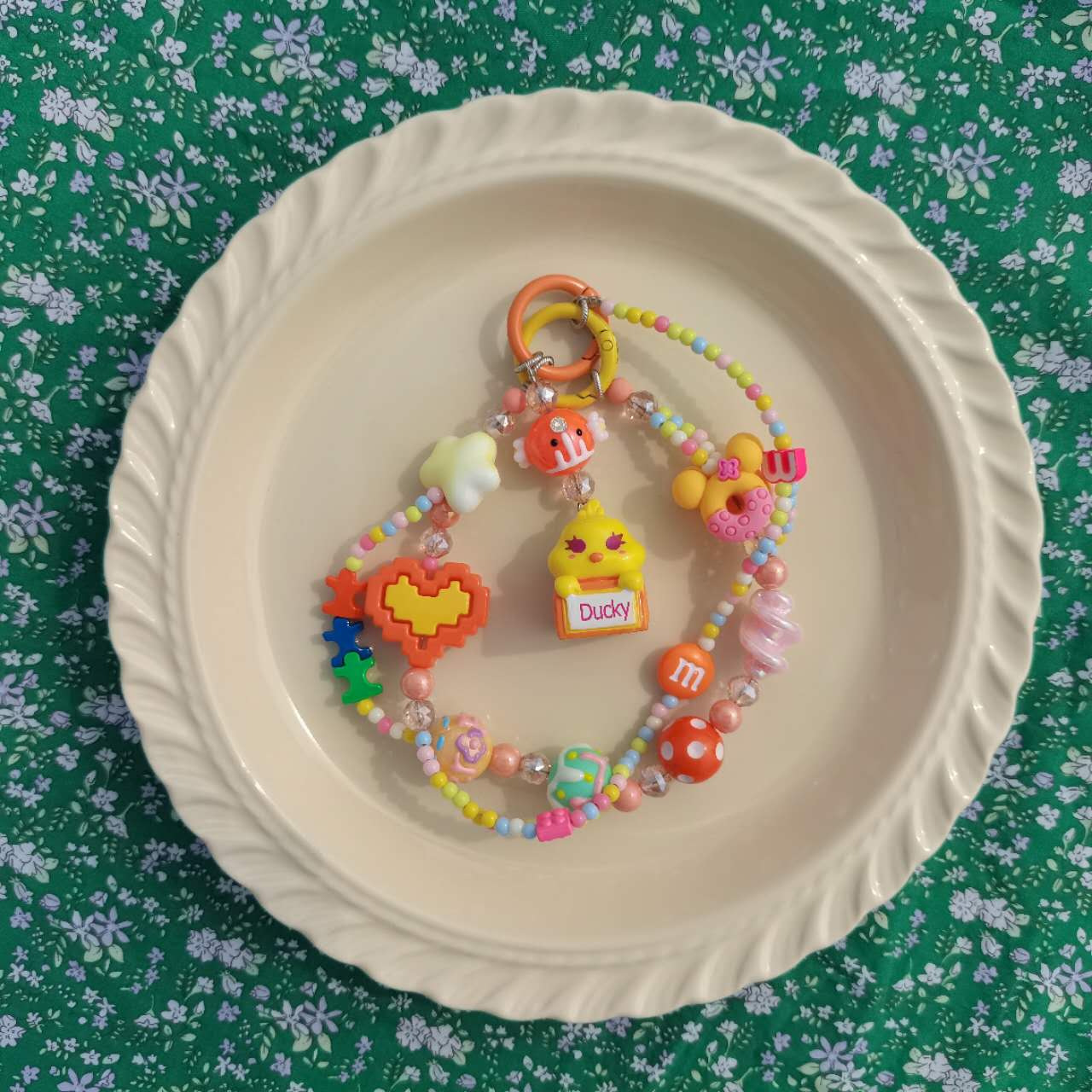 An array of colorful, handmade accessory beads spread out on a white plate