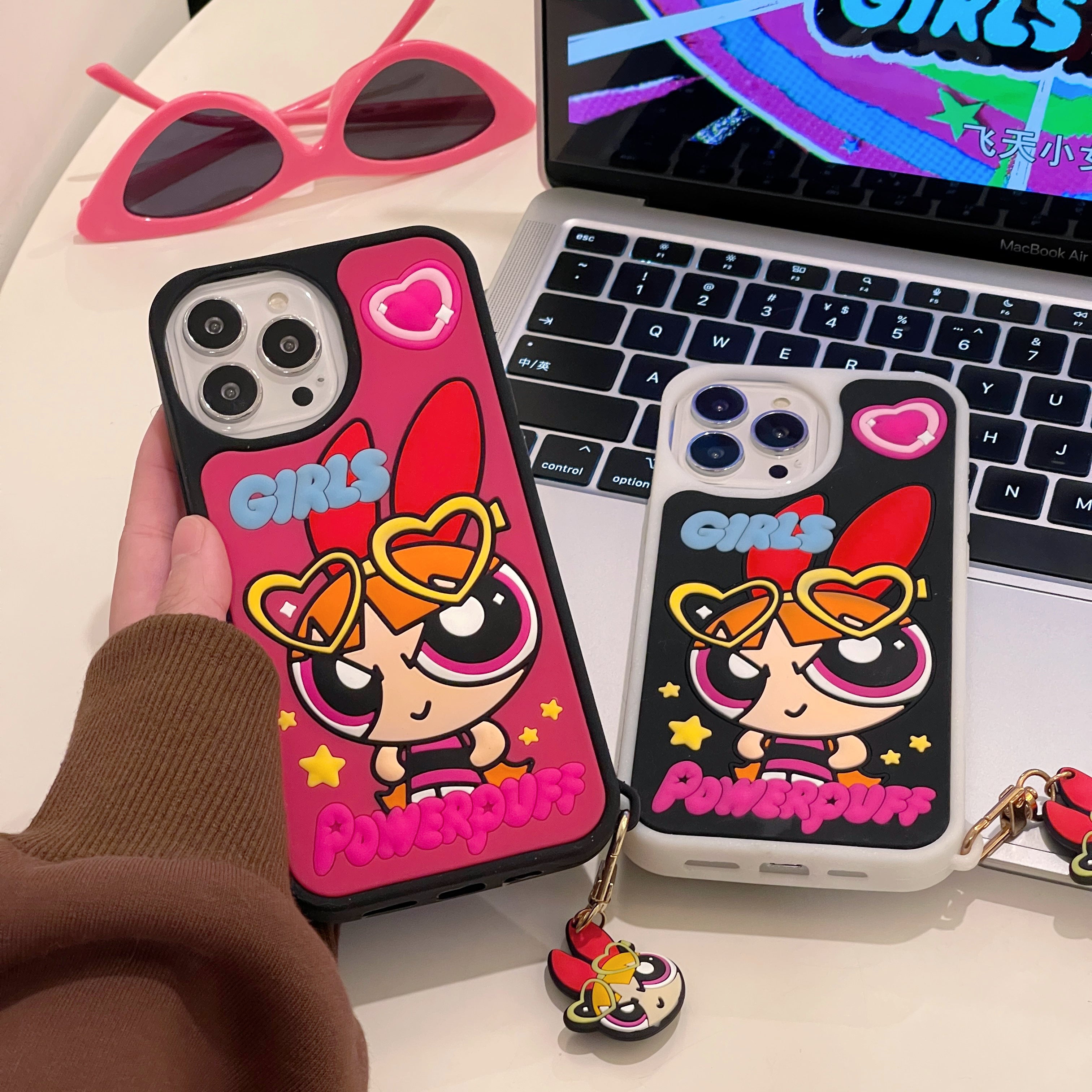 Pair of Powerpuff Girls iPhone cases for iPhone 14 and 13 series on display