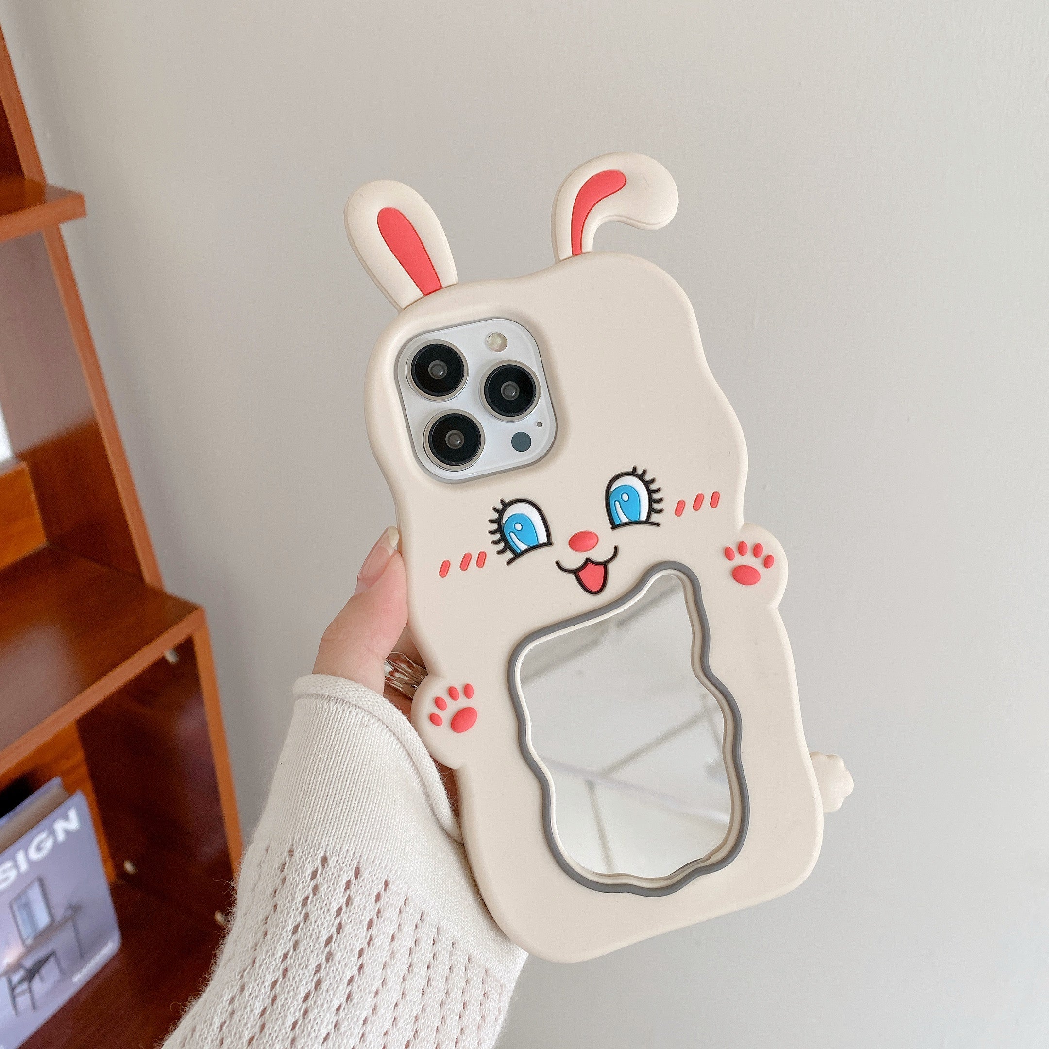 Individual displaying a soft silicone iPhone case with rabbit artwork