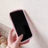 Person holding a soft pink Hello Kitty silicone iPhone case