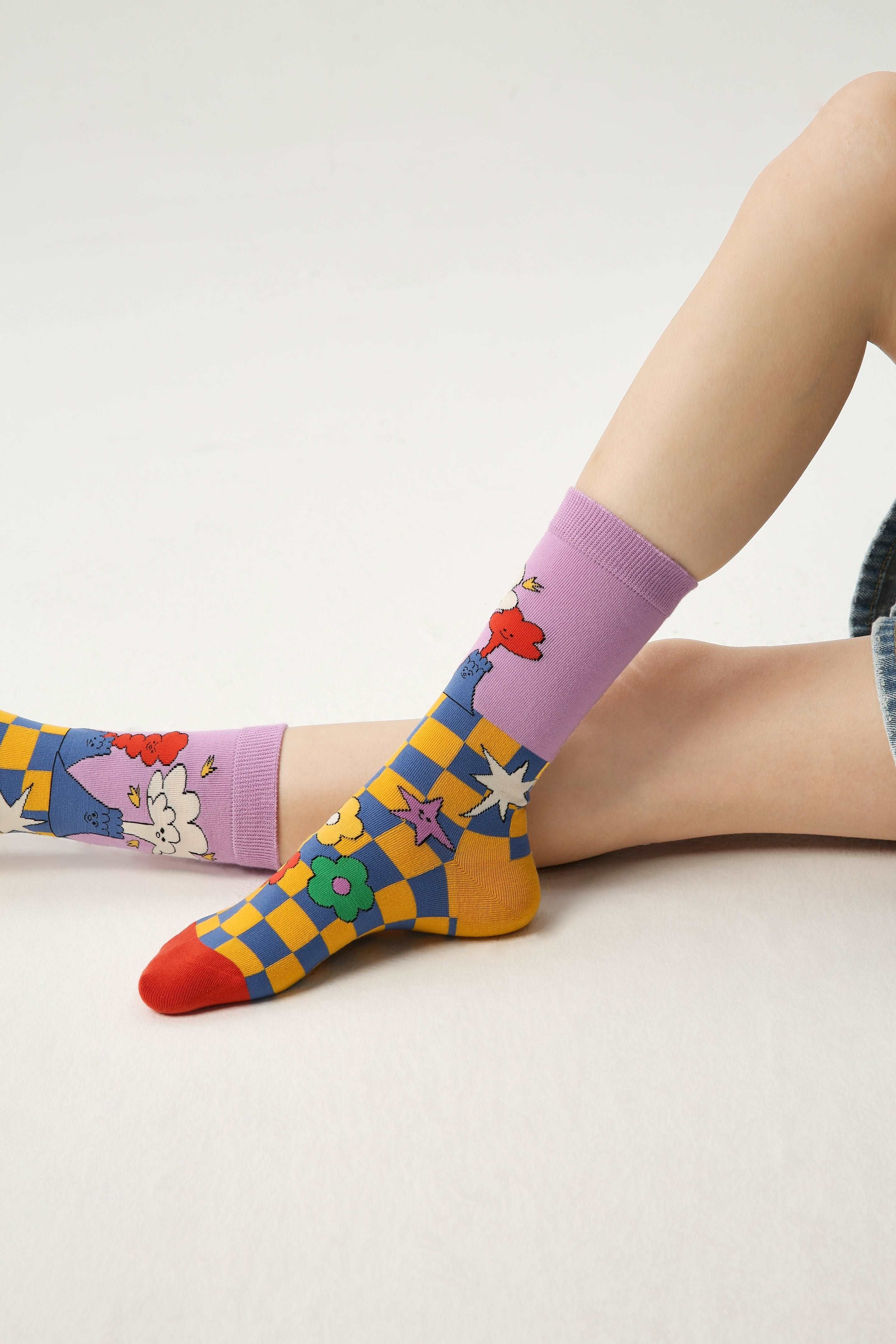 Legs featured in vibrant rainbow-colored socks with playful motifs