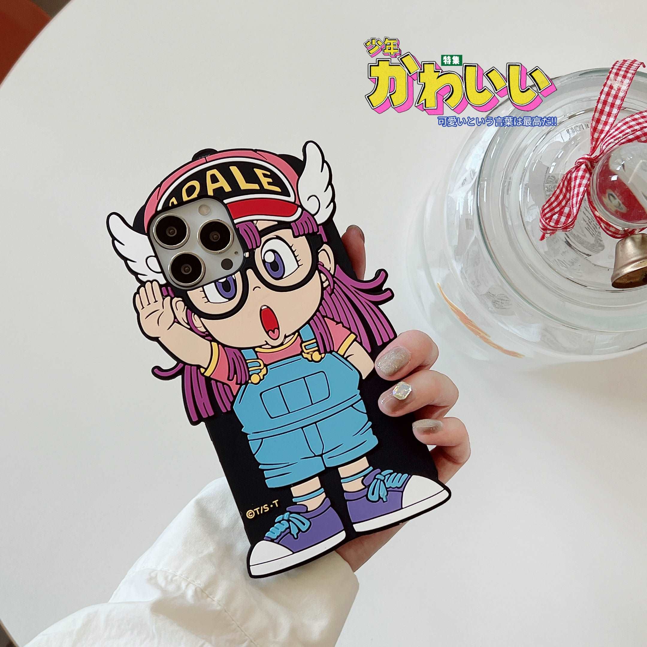 Hand holding an iPhone 14 Pro Max with a cute Arale character case