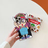 Close view of a hand holding an Arale cartoon character iPhone case