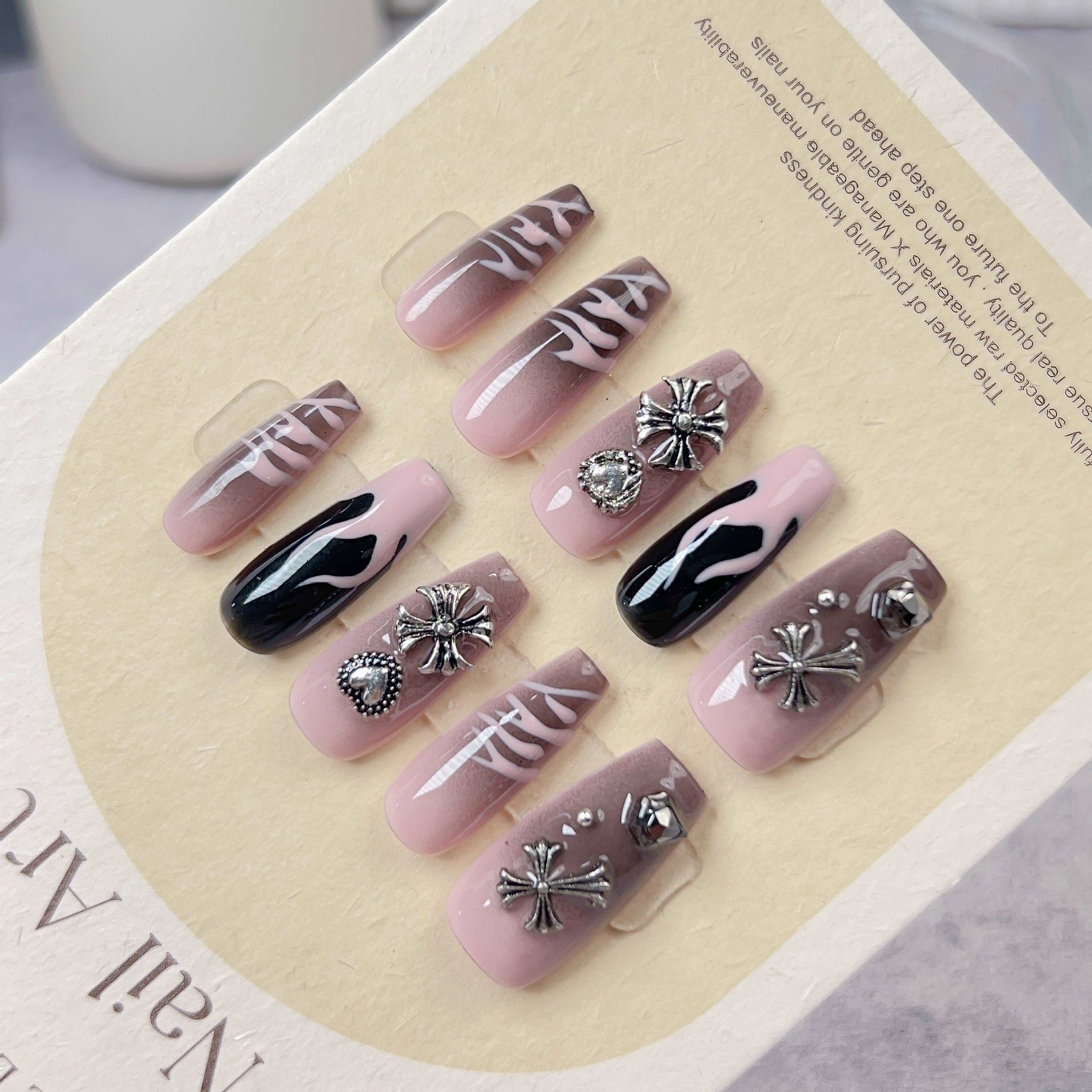 Black and pink floral press-on nails in packaging