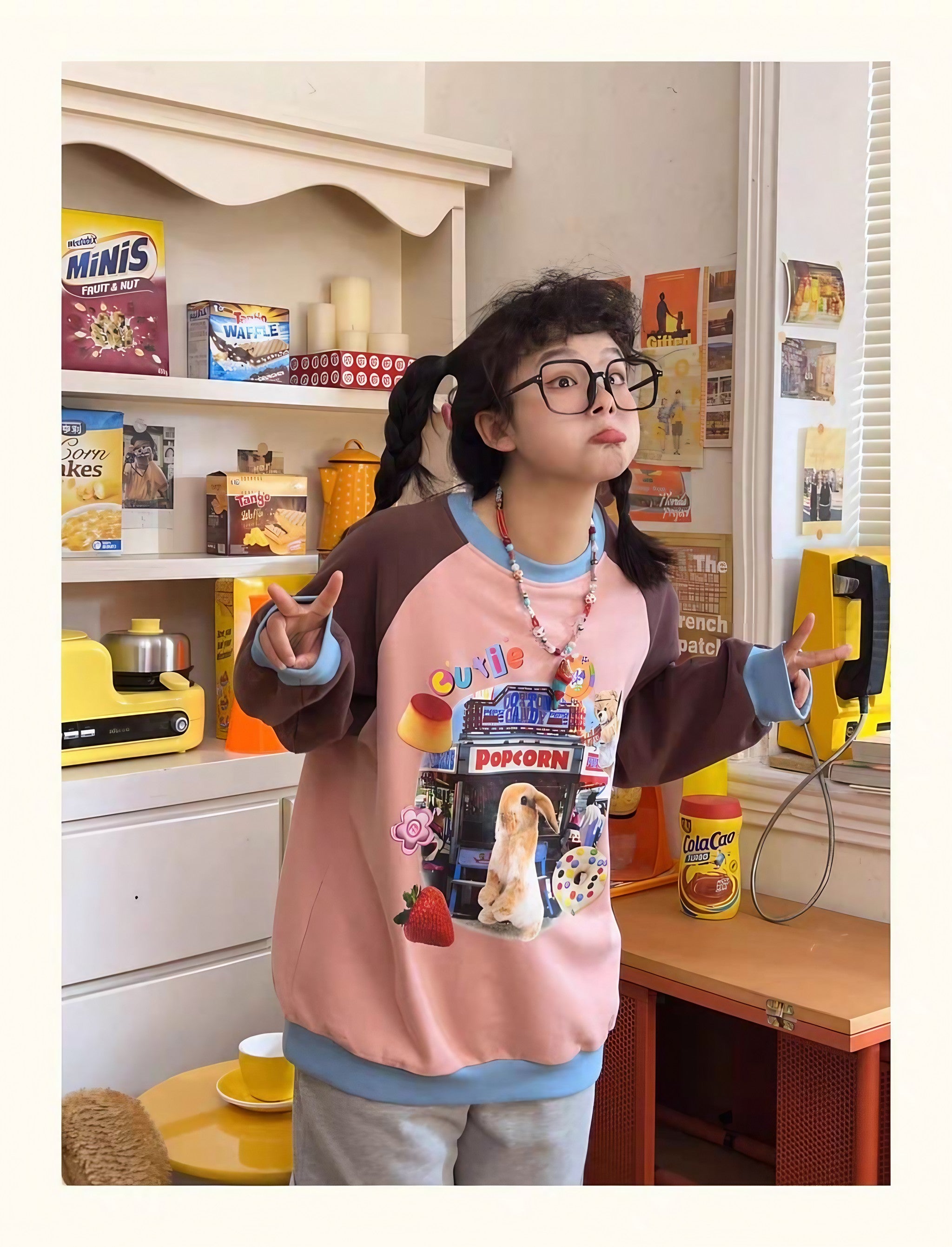 A girl in eyewear and a pink Gen Z aesthetic sweatshirt with a bunny print