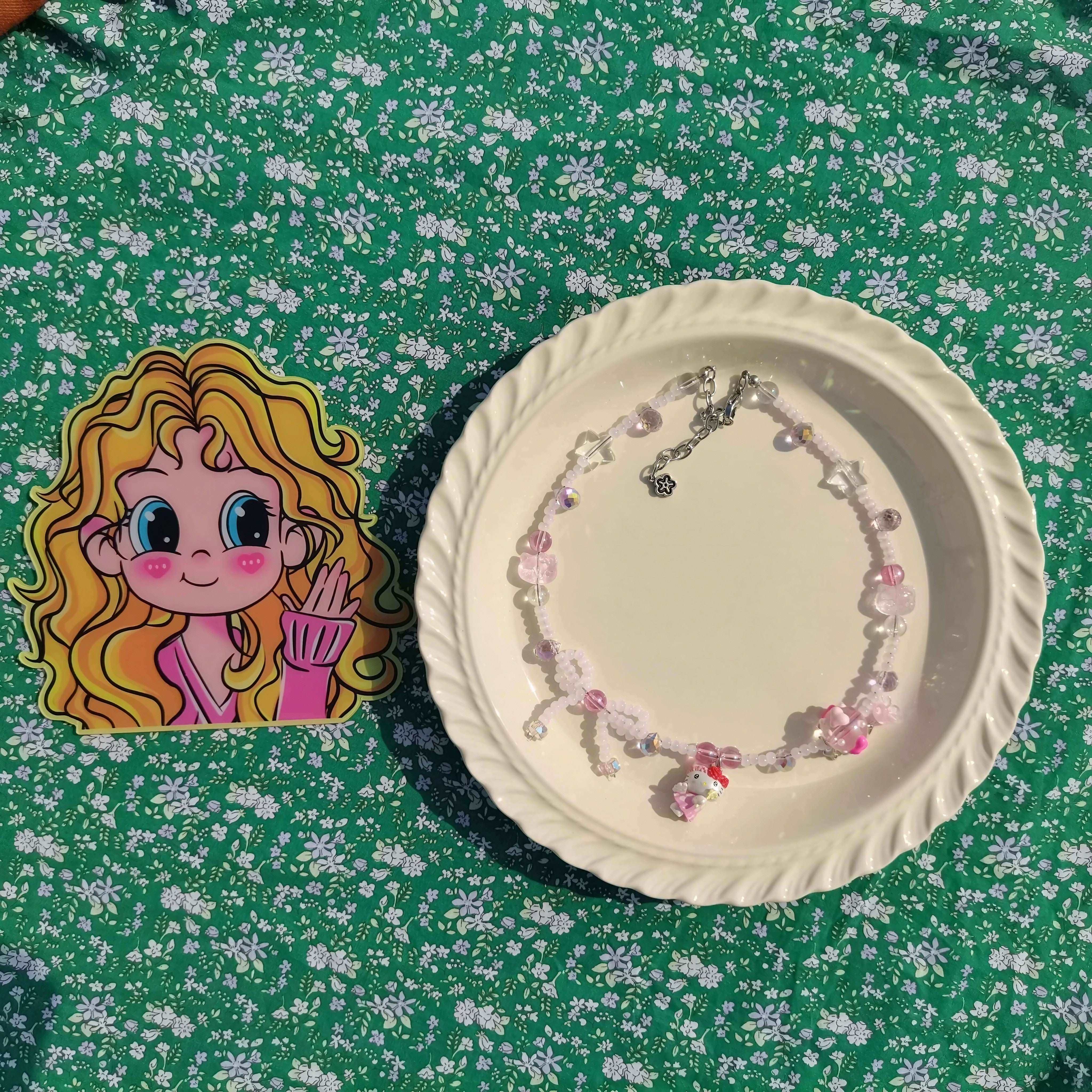 Hello Kitty inspired necklace with pink beads presented on a plate