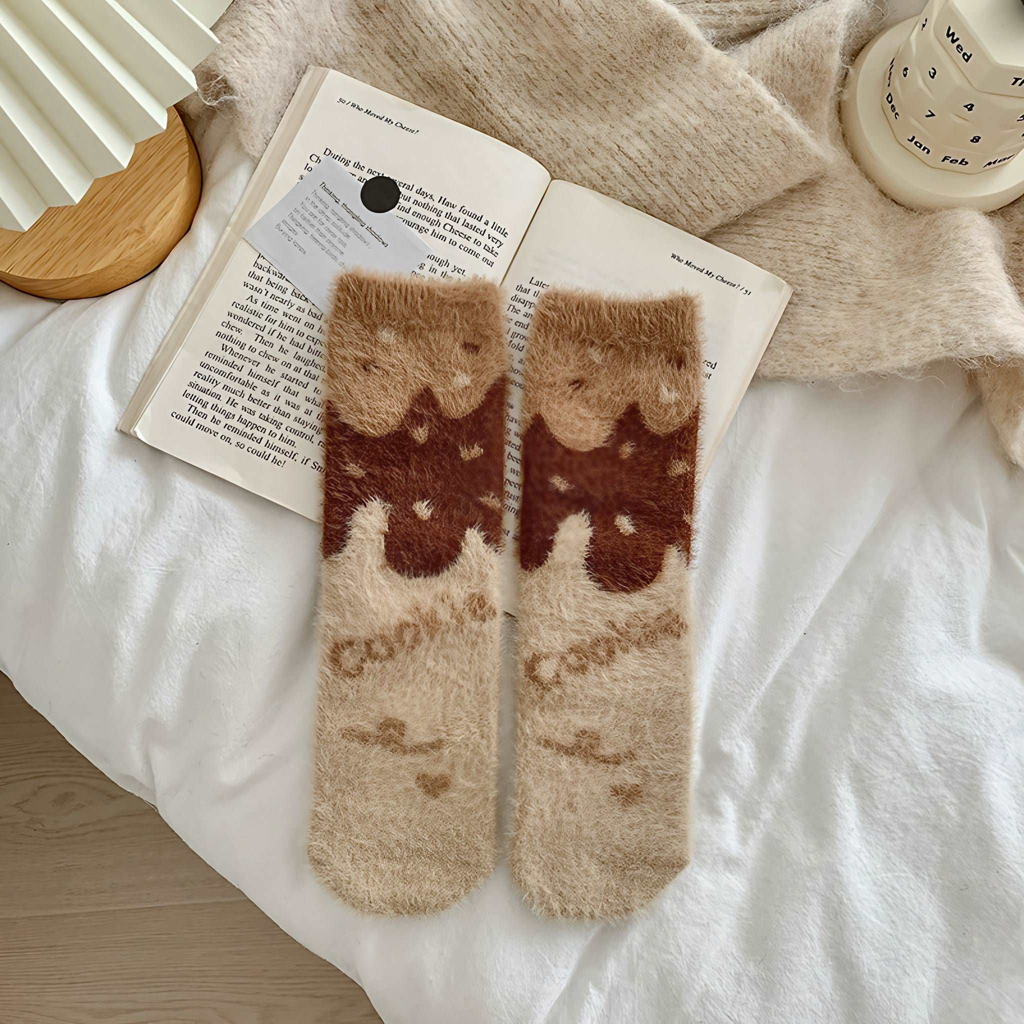 A relaxing scene with plush socks, a good read, and a hot beverage
