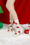 Close-up of cozy Christmas socks adorned with red apple patterns worn by a woman