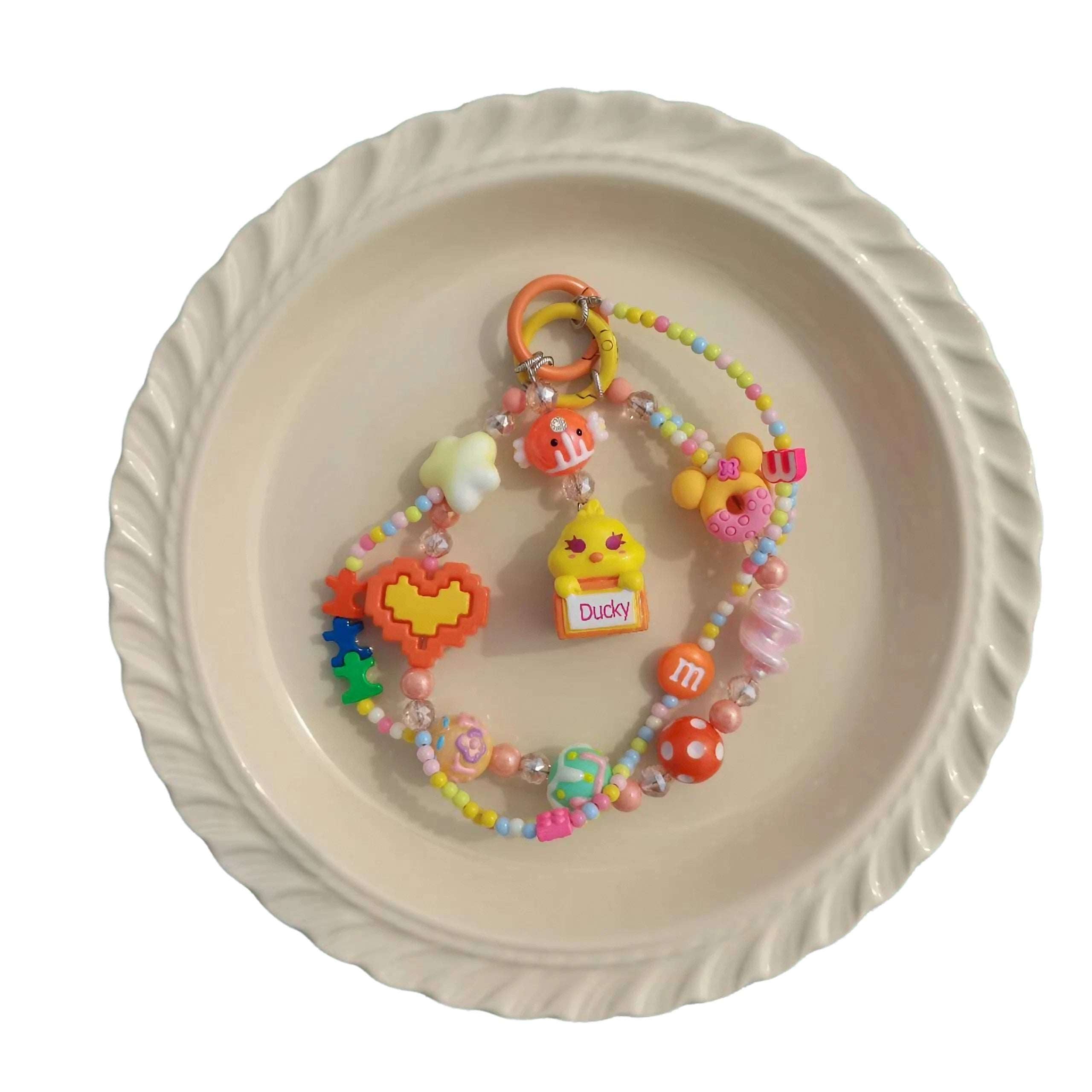 An array of colorful, handmade accessory beads spread out on a white plate