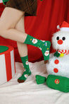 Green holiday socks with a snowman design modeled by a person