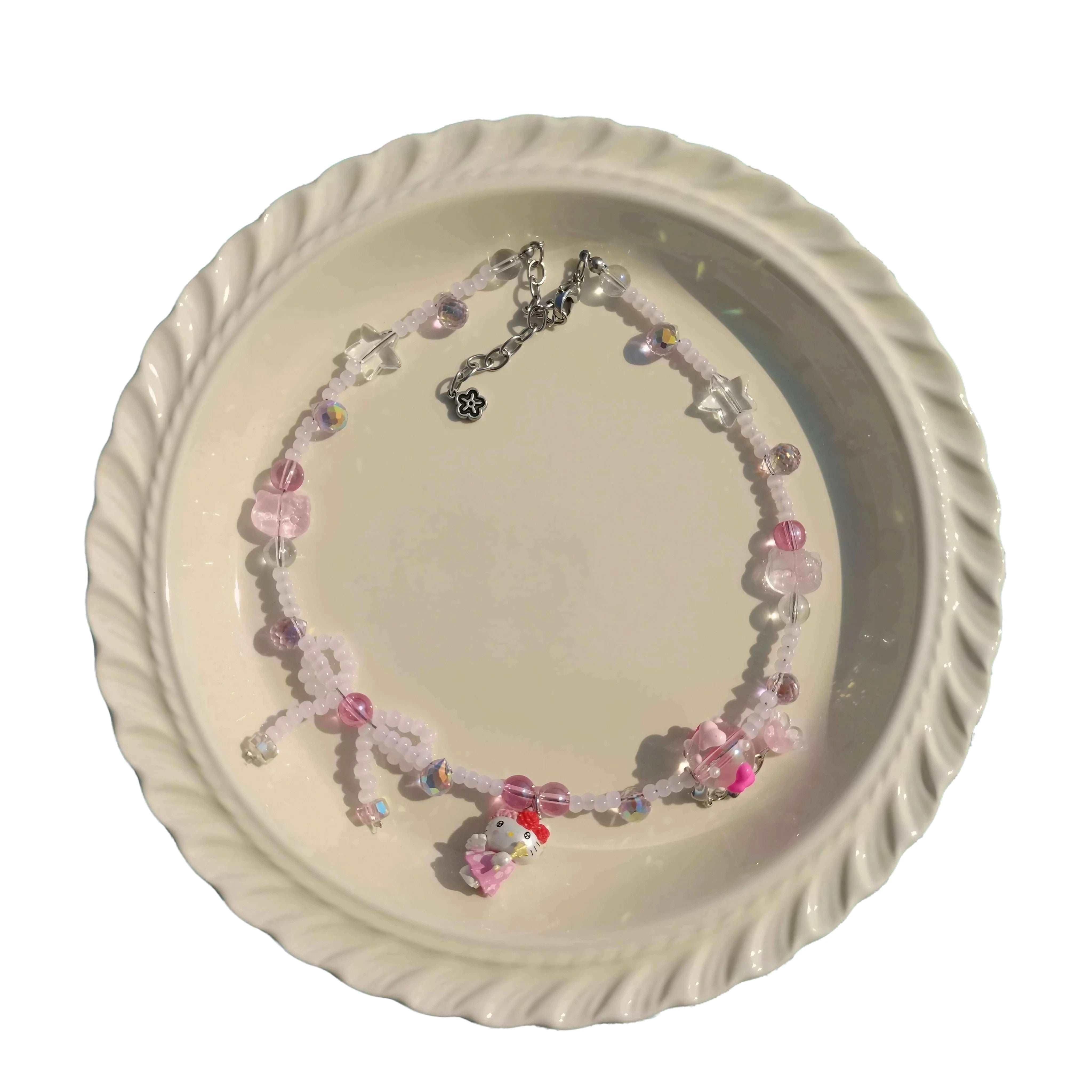 Artisanal Hello Kitty themed pink necklace displayed on a white dish