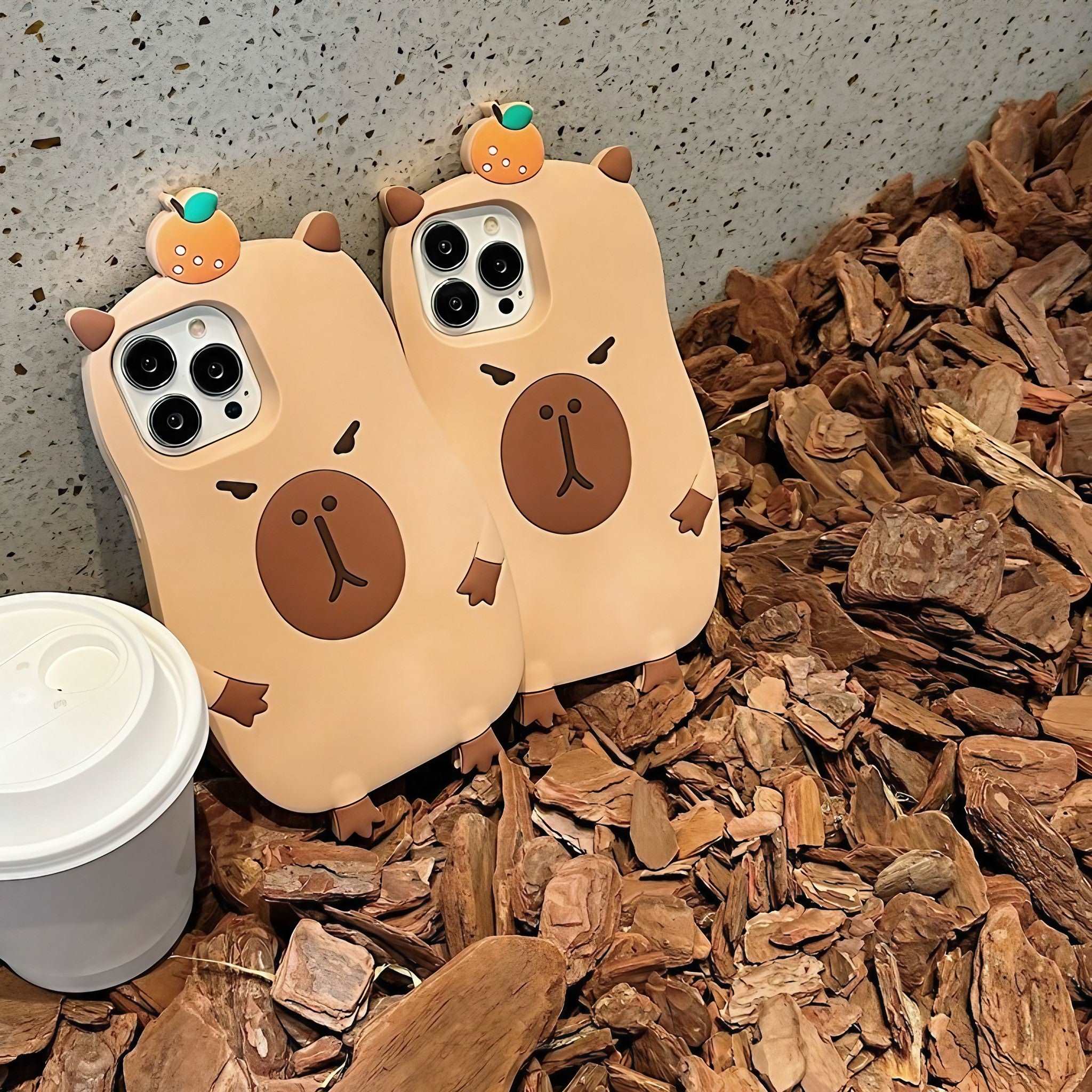 A cozy setting with twin Capybara iPhone cases beside a warm cup of coffee