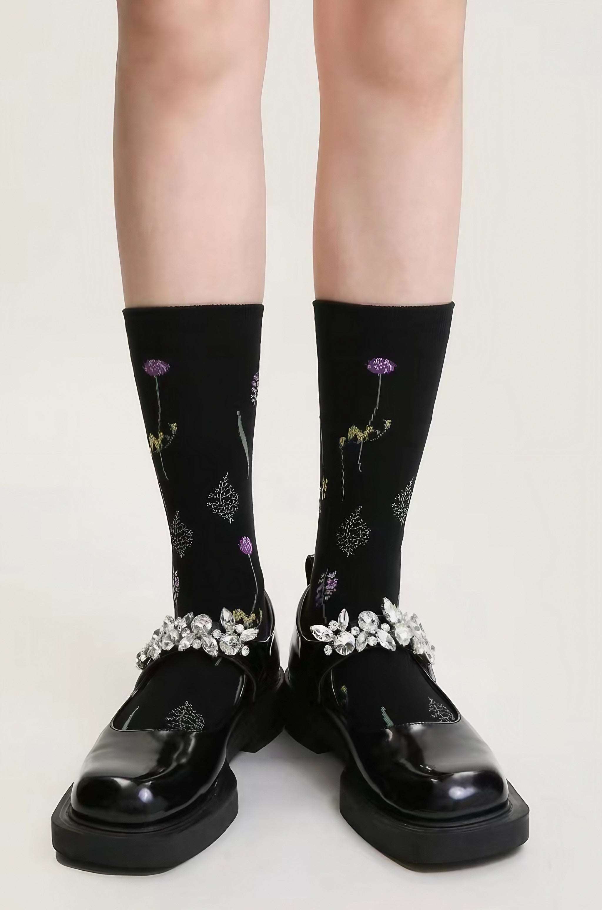 Fashionable black socks embellished with floral designs on female feet