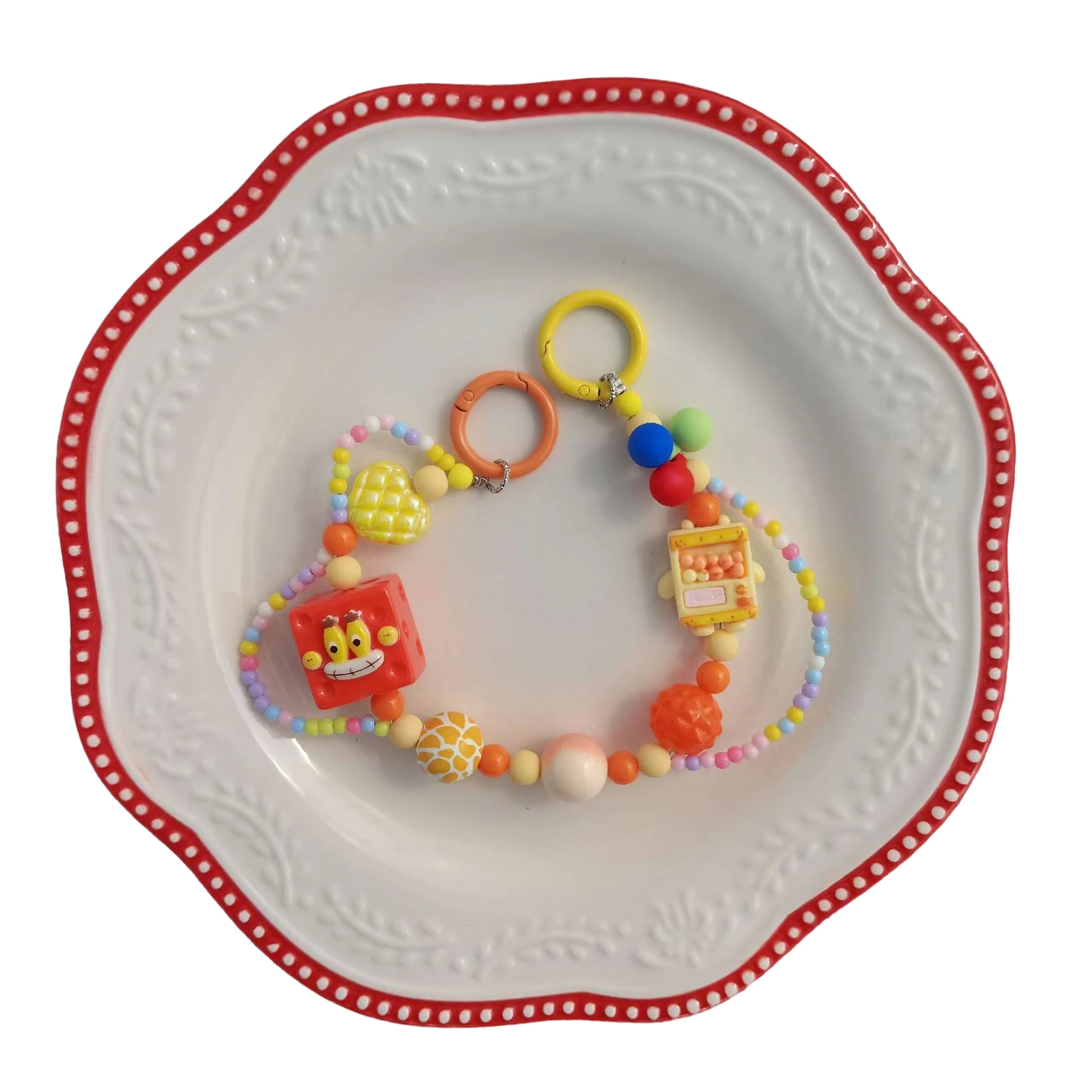A decorative SpongeBob bag chain and beaded accessory presented on a plate