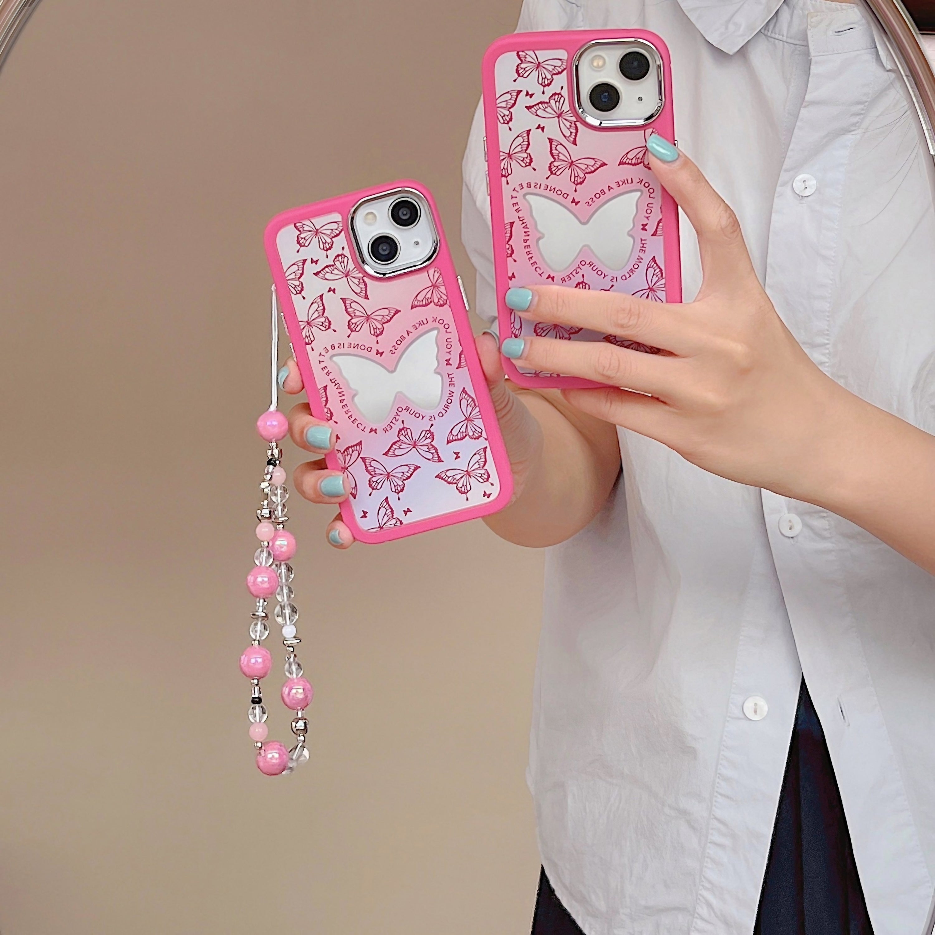 Close-up of a pink butterfly iPhone case with an attached phone chain and mirror for iPhone 14 series