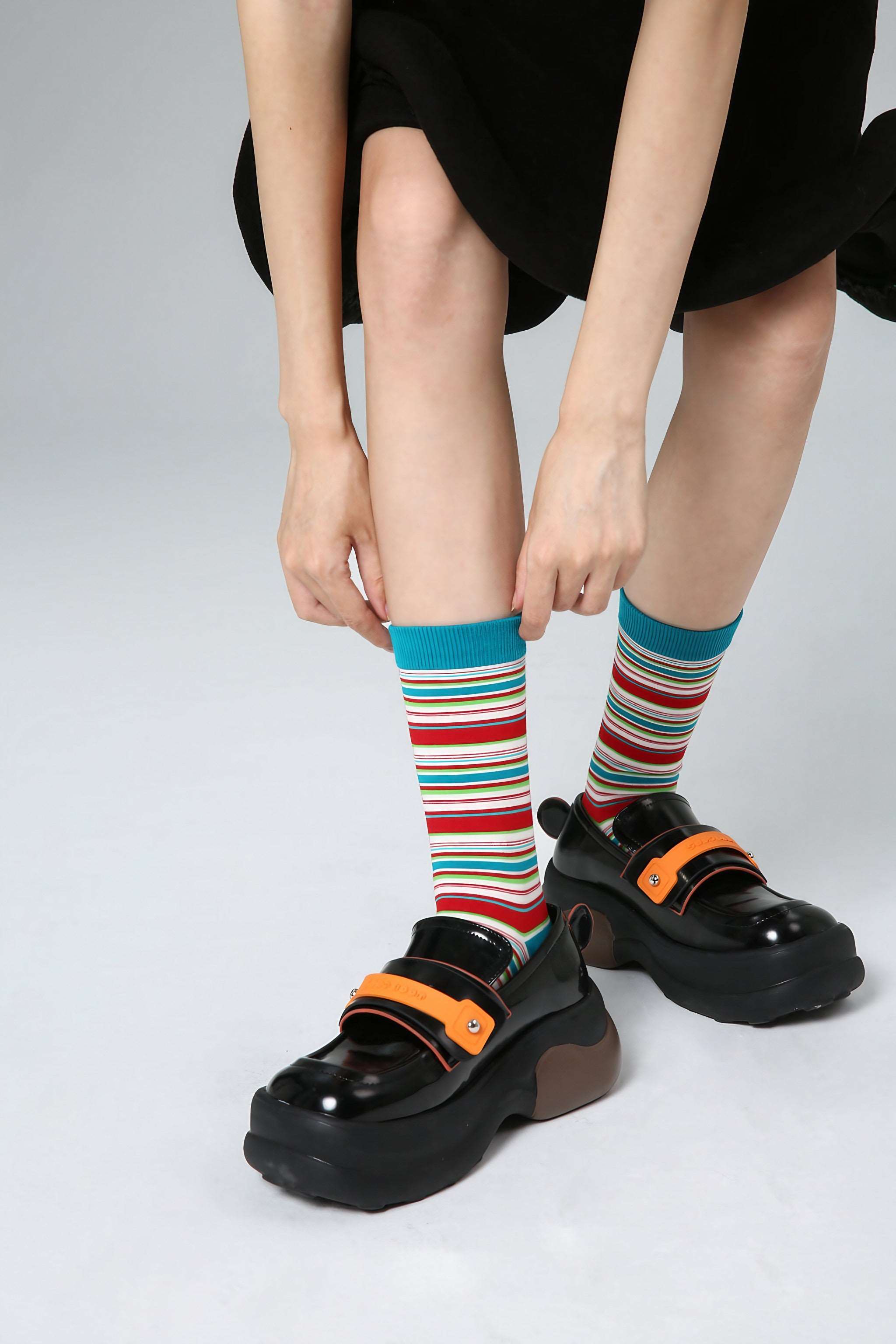 A woman showcasing her Blackpink Funky Socks paired with sleek black footwear