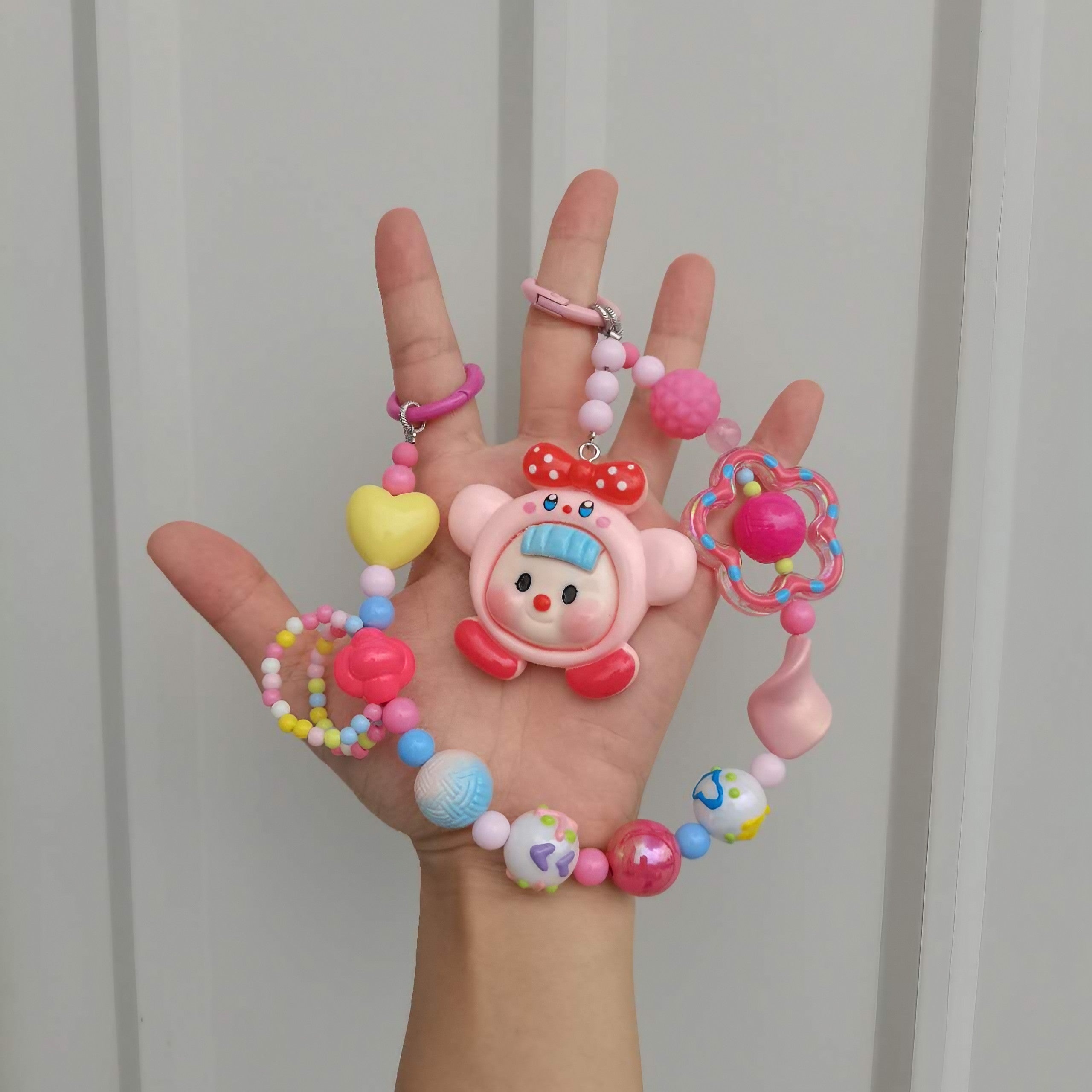 A hand displaying a Pink Princess Bag Chain with Kirby Keychain attached