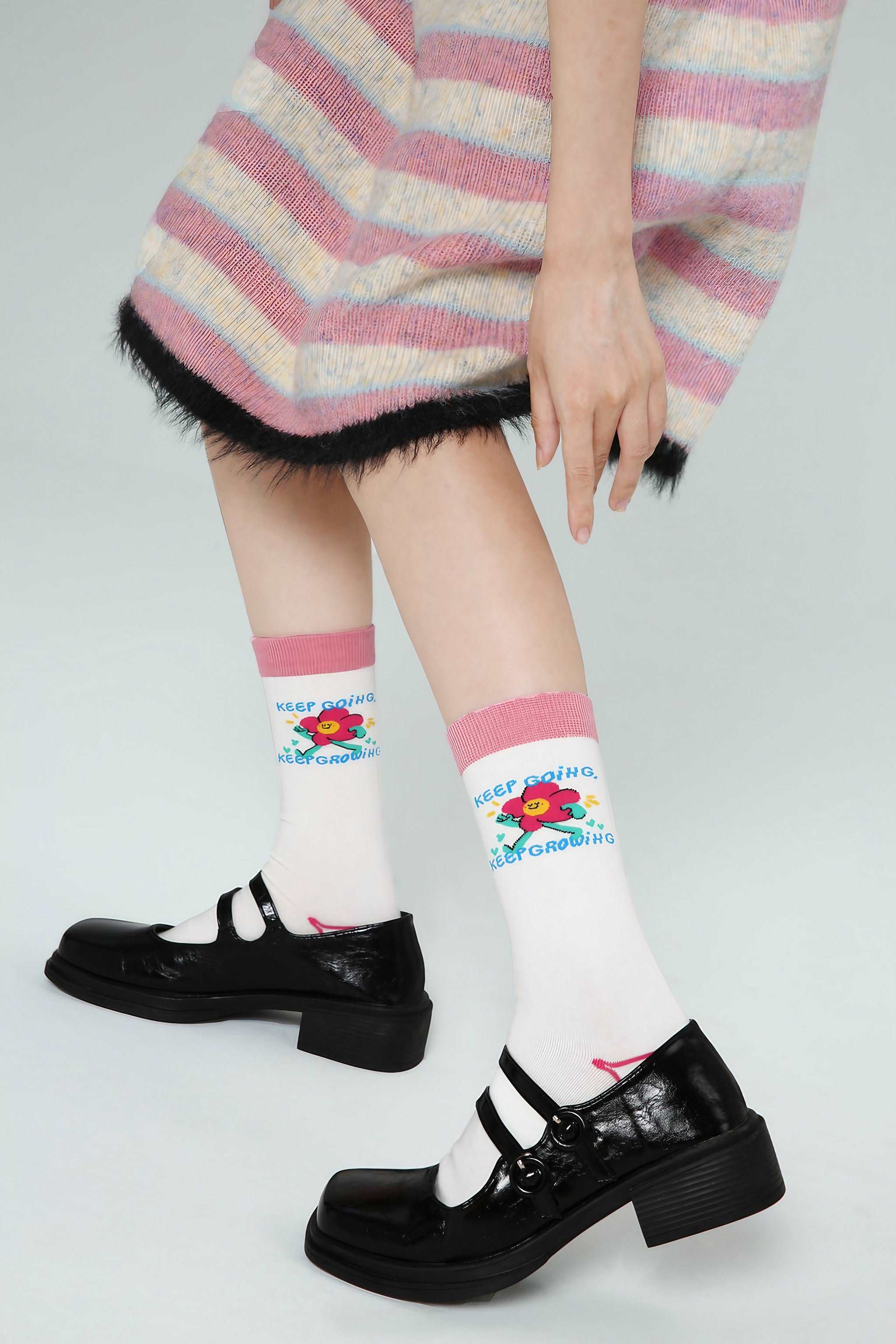 Woman's feet in black shoes showcasing socks with a vivid pattern