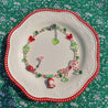 A red Hello Kitty beaded necklace artistically arranged on a white plate