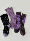 Assortment of three socks in purple and black with flower designs