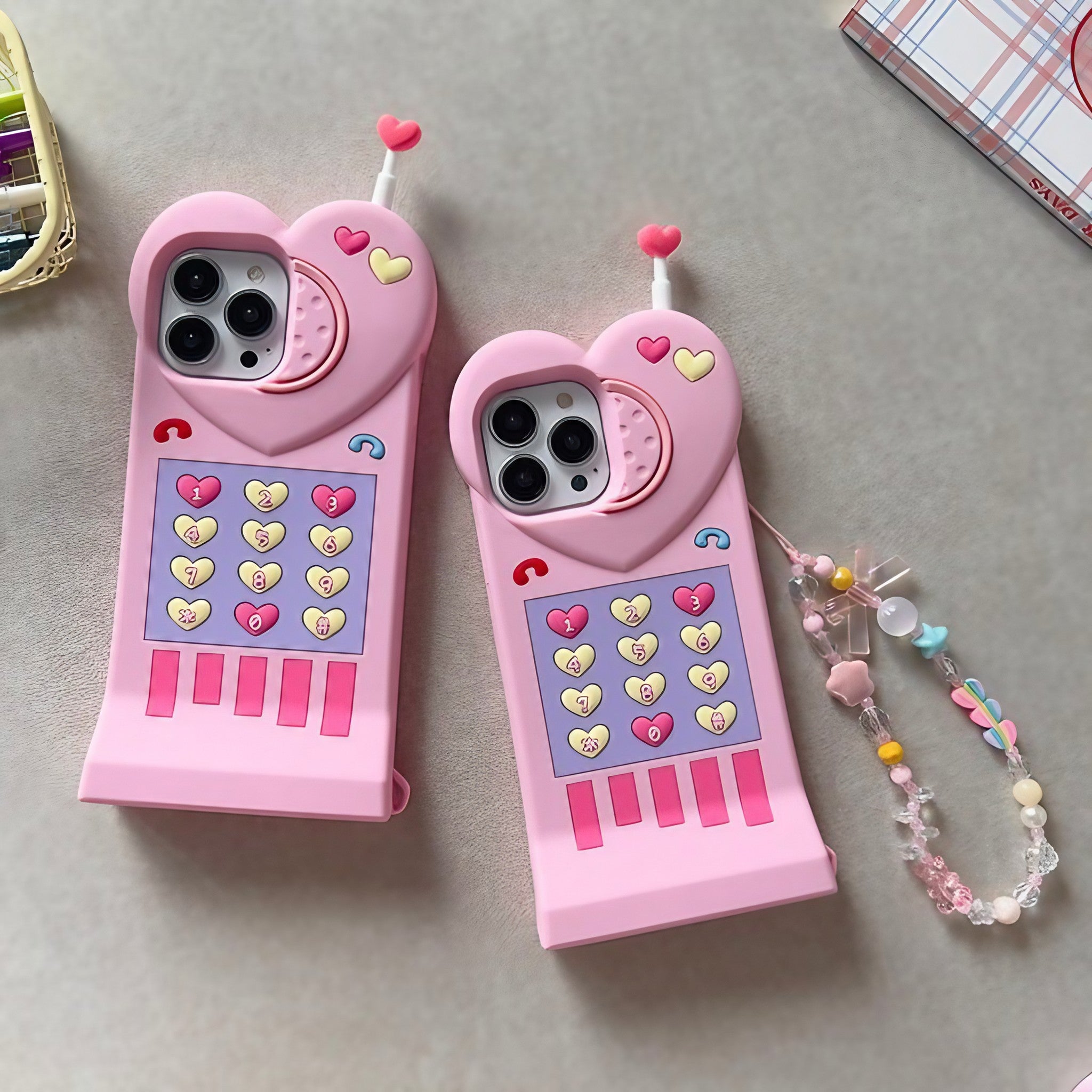 Pair of pink iPhone cases with heart motifs for the iPhone 14 and 13 series