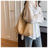 Casual style with woman in white shirt and jeans carrying a tan autumn shoulder bag