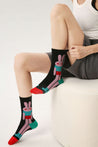 Woman seated on a stool flaunting cartoon character socks