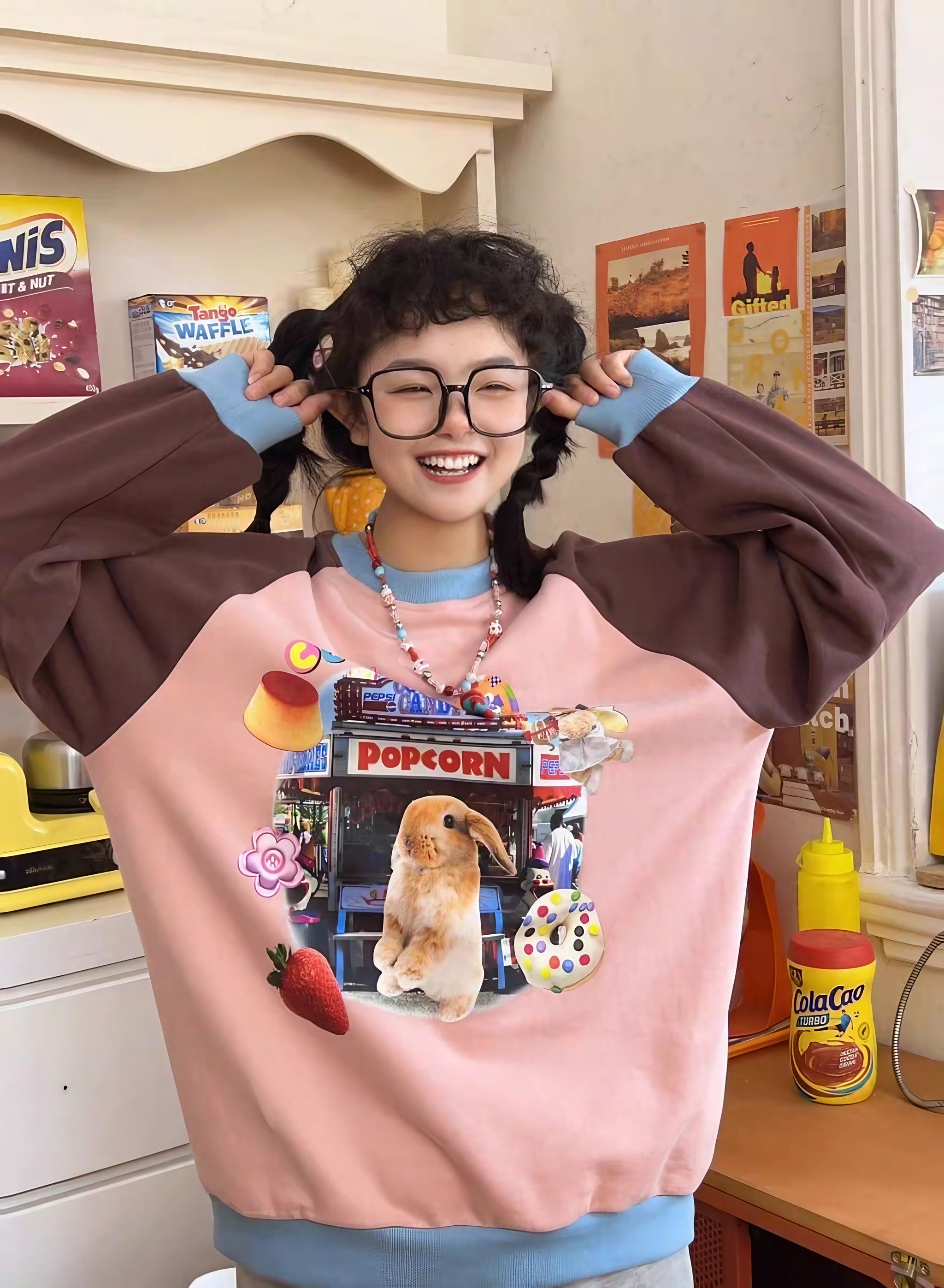 A girl with glasses wearing a Gen Z style sweatshirt with a rabbit graphic