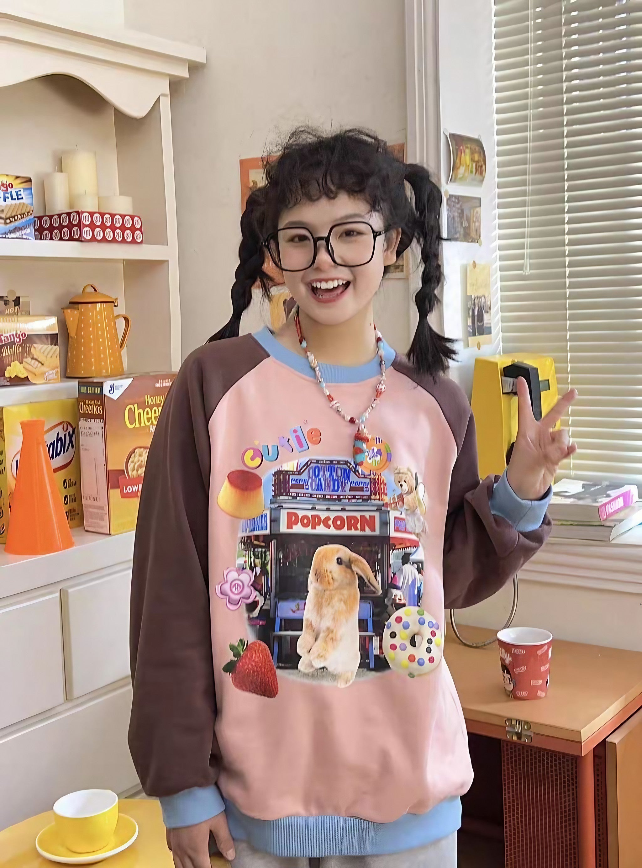 A bespectacled girl modeling a Gen Z aesthetic sweater with a rabbit print