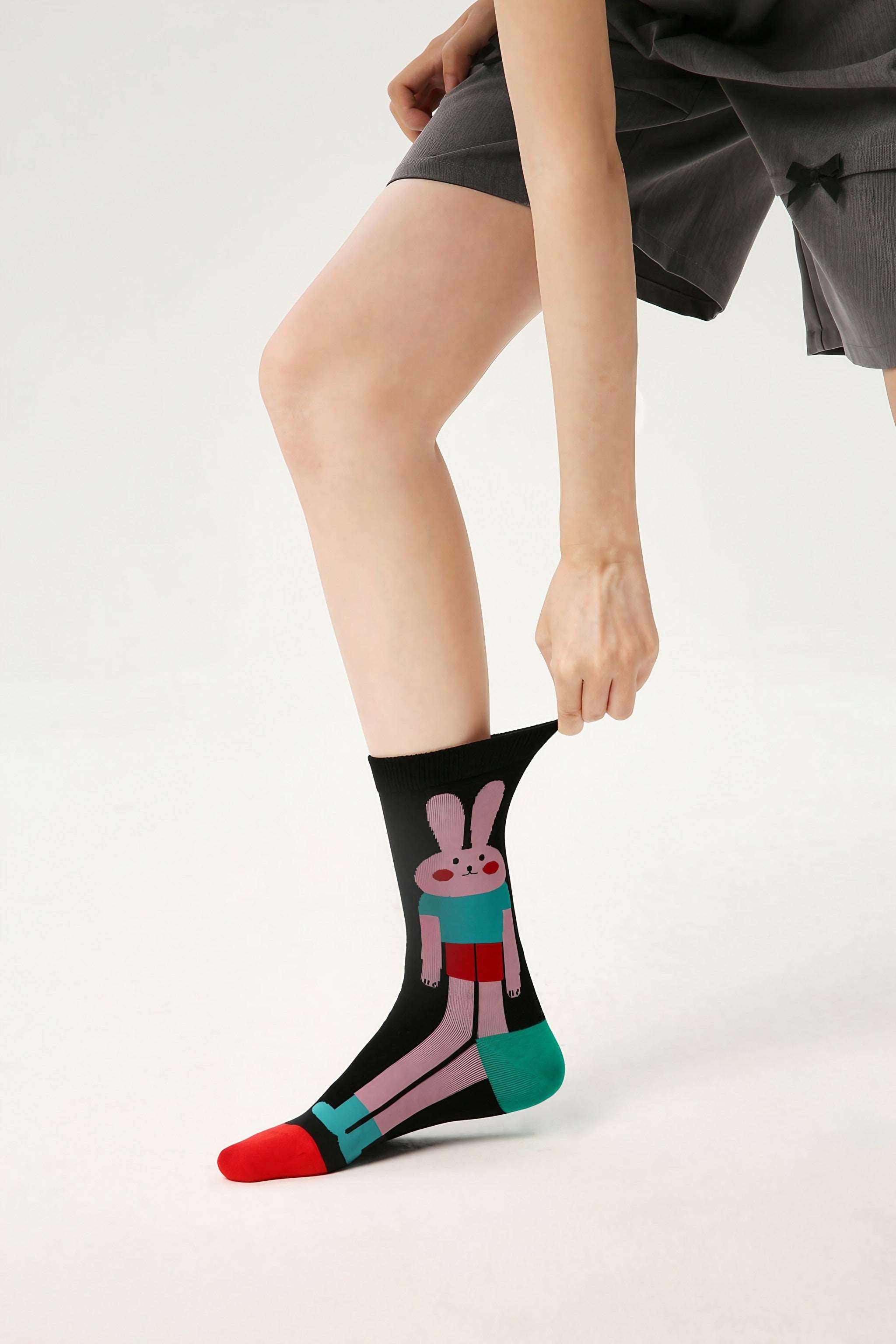 Close-up of a woman's foot in a black and pink rabbit sock