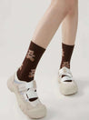 Detail of the Brown Bear Socks with bear patterns, paired with white sneakers