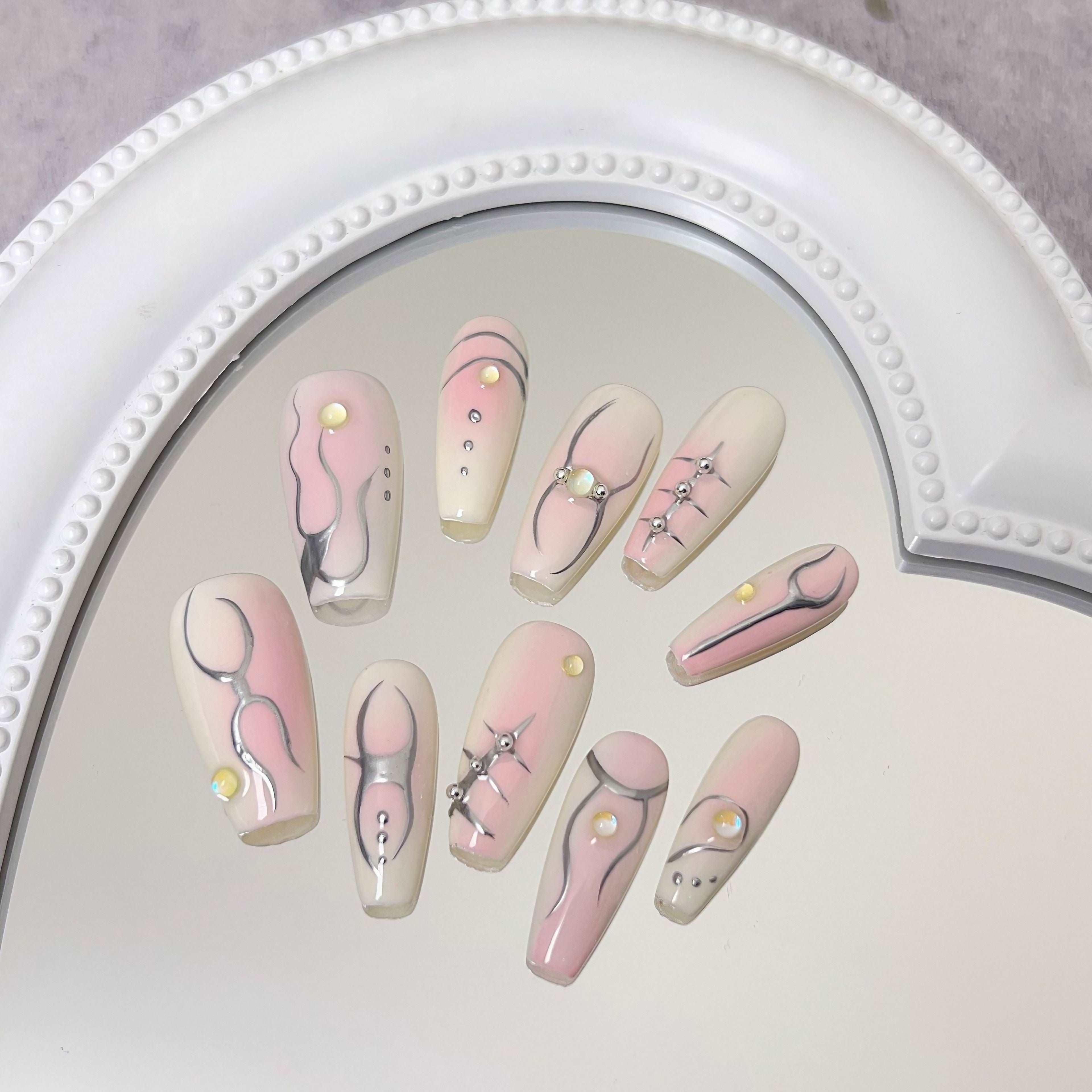 A collection of Ballet Coquette Daily Nails displayed on a reflective surface