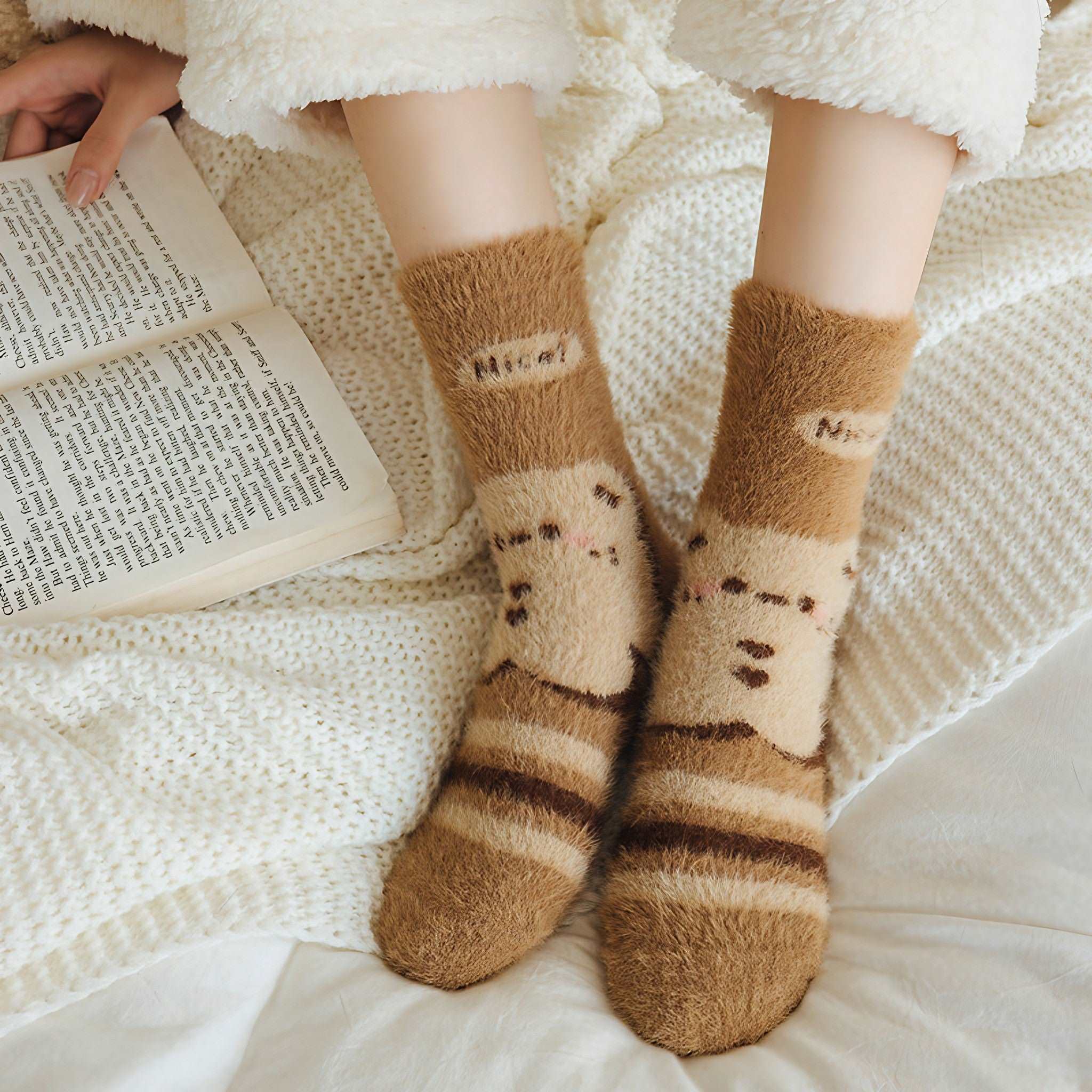 Relaxed woman reading a book while wearing warm brown bear socks