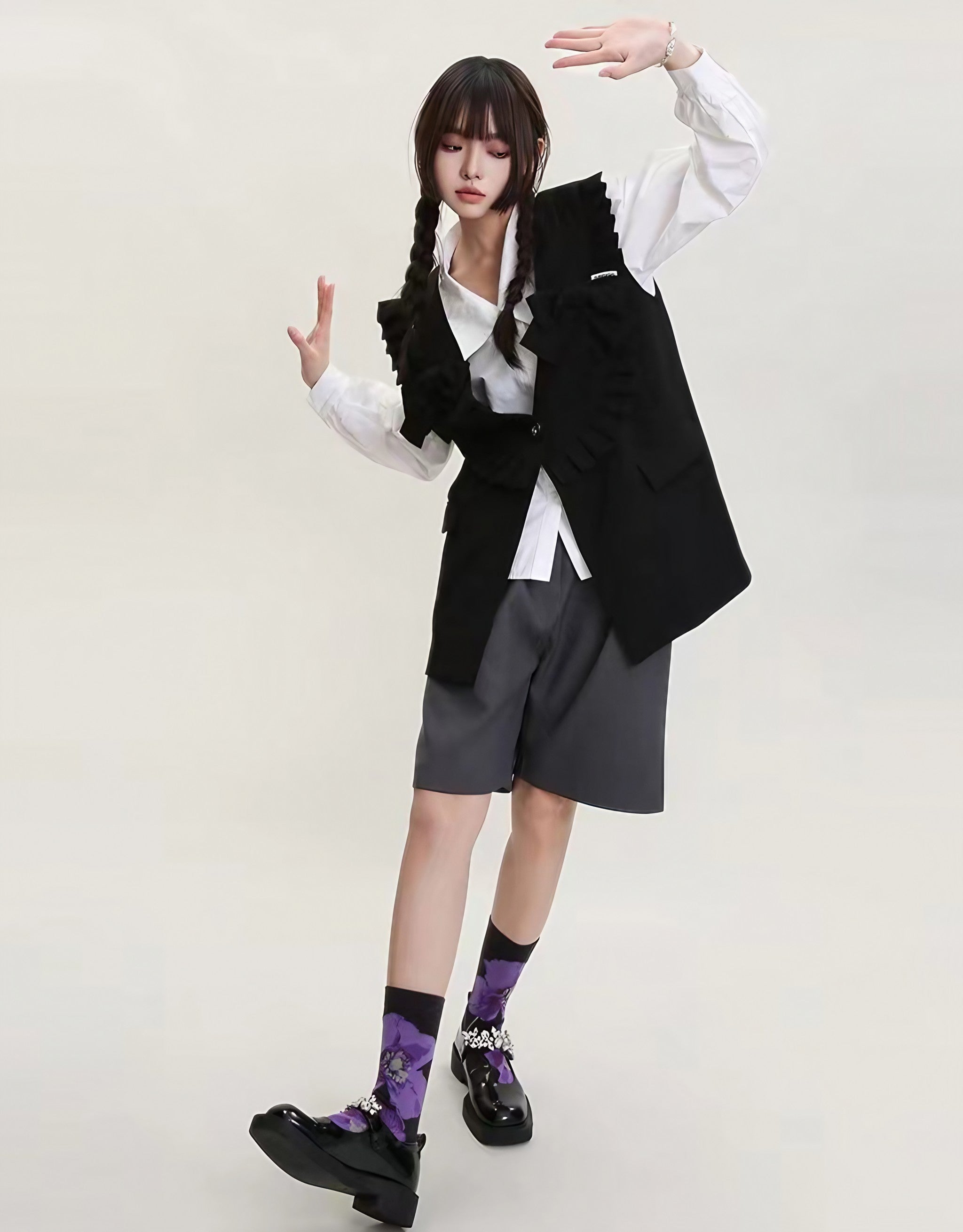 Woman posing in a black vest, shorts, and vibrant purple socks