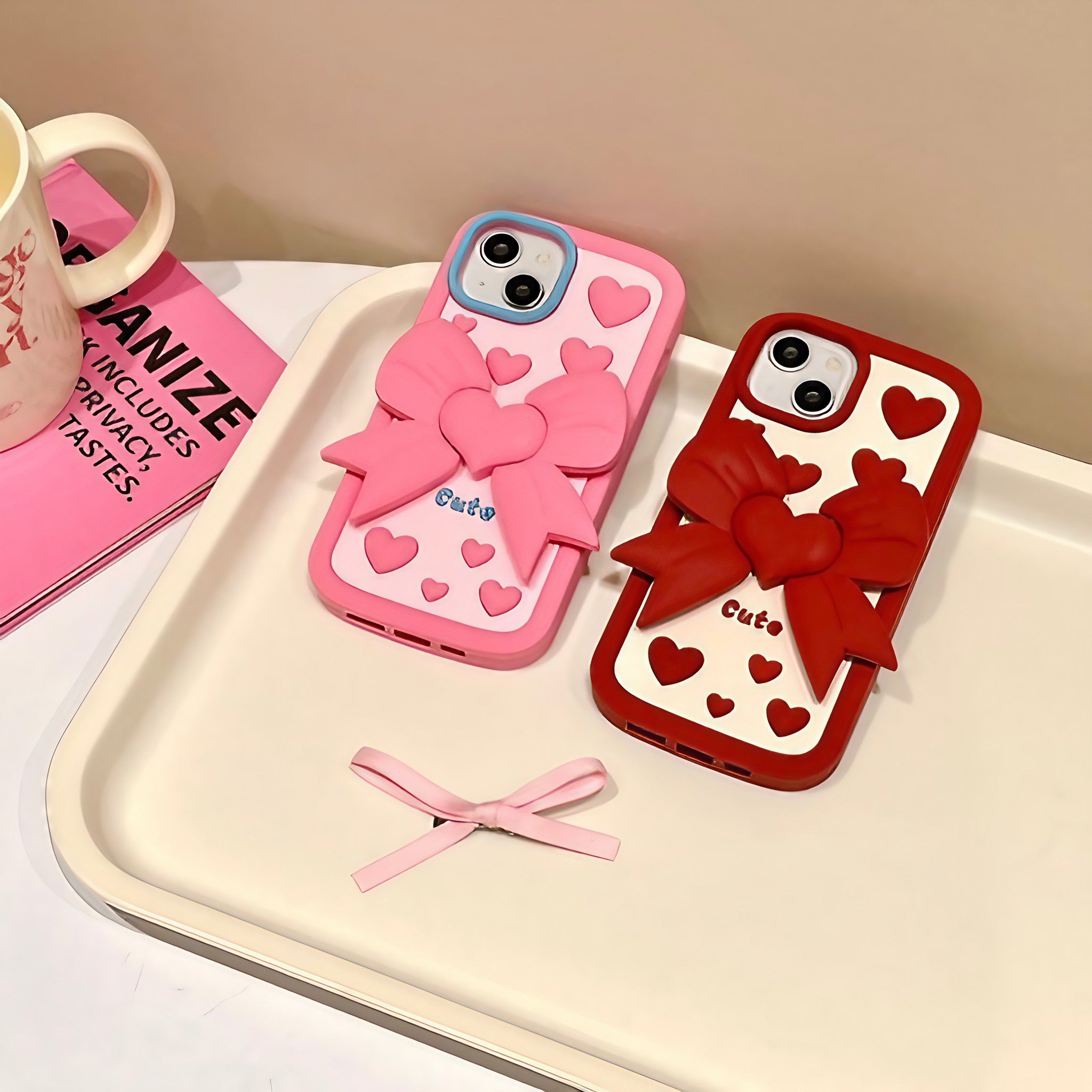 A duo of pink and red coquette iPhone cases adorned with heart motifs