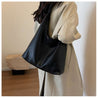 Fashionable black coat paired with matching autumn shoulder bag