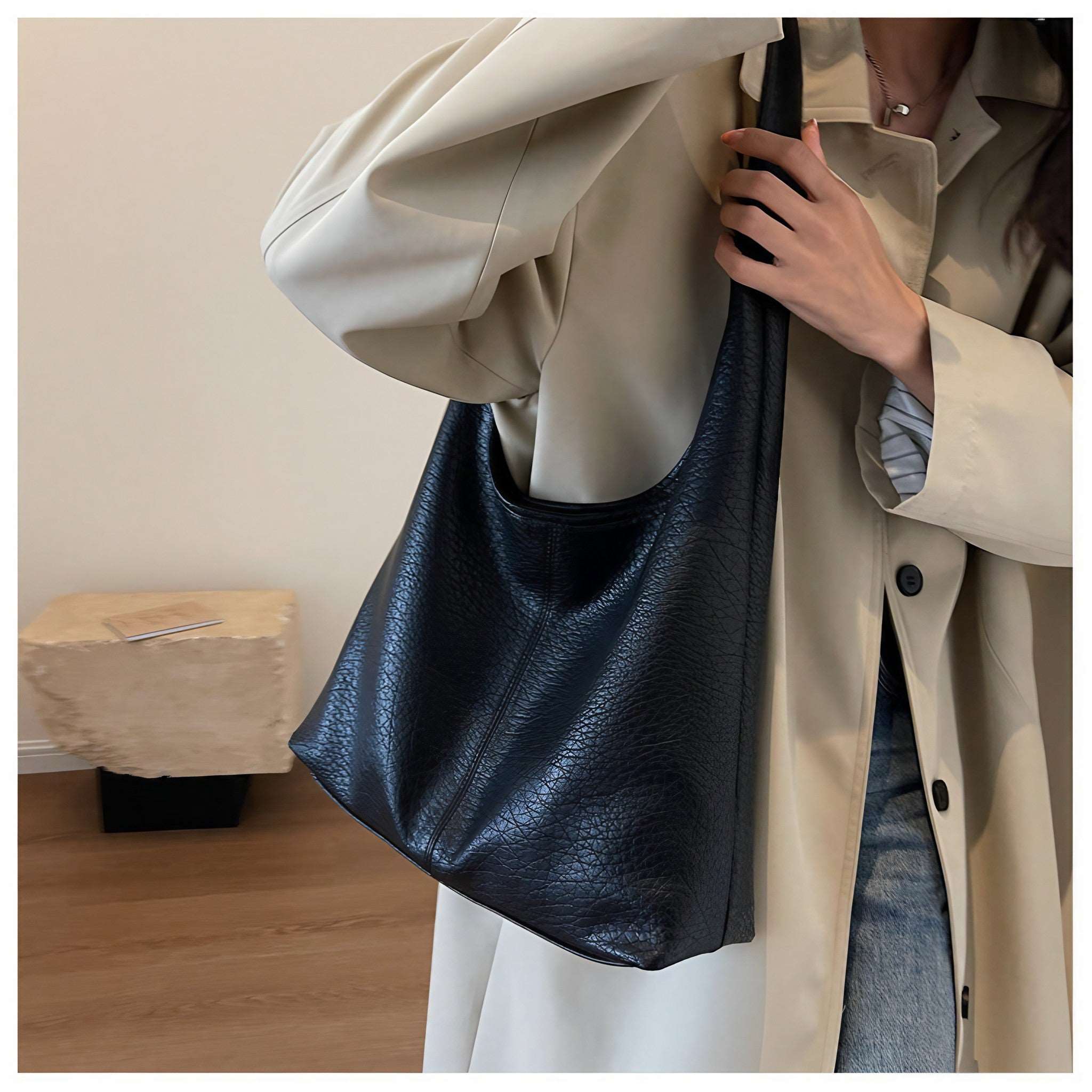 Elegant woman posing with a black autumn shoulder bag wearing trench coat