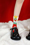 Black shoes complemented by socks featuring a whimsical snowman design on the floor