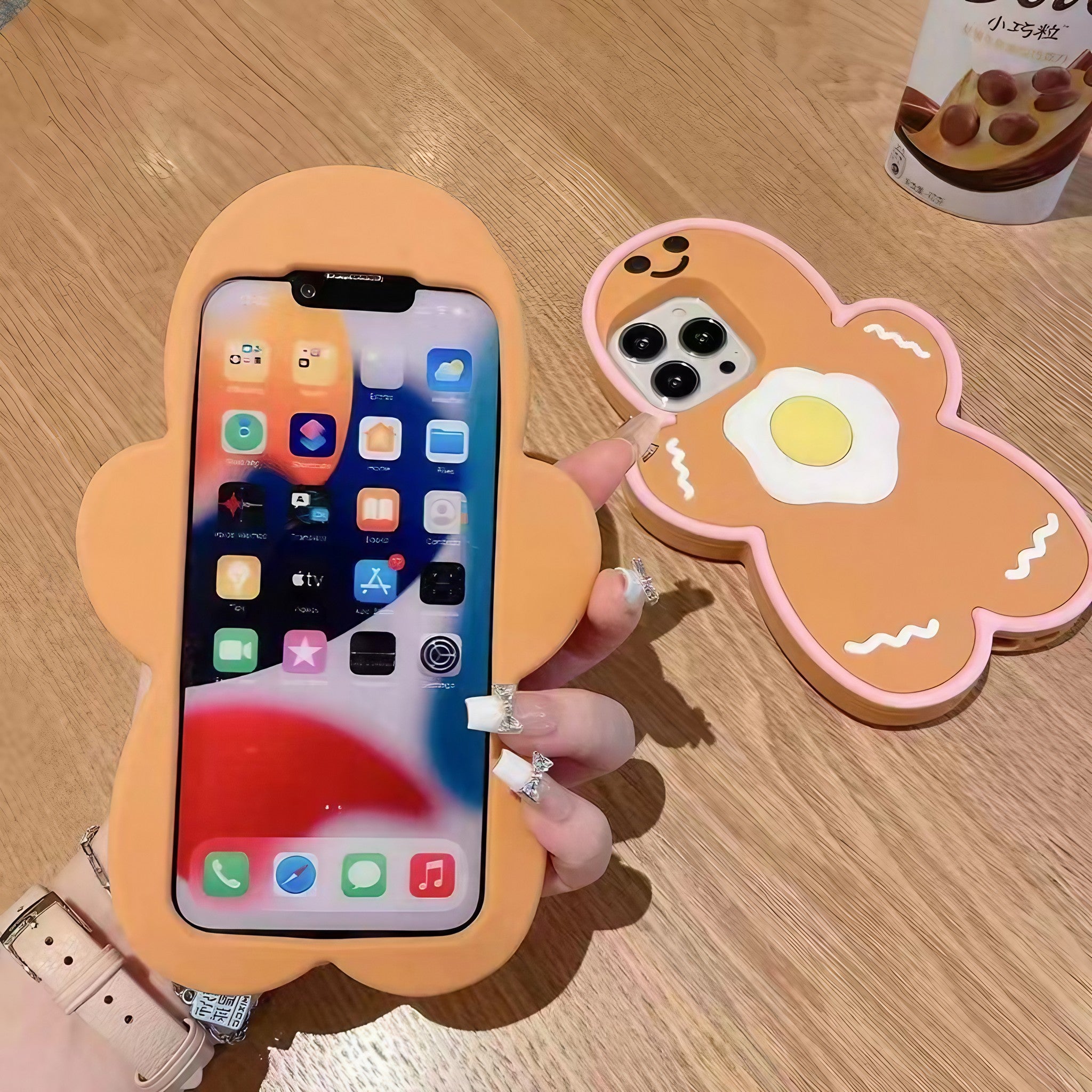 A hand showcasing a kawaii-style bear design on an orange iPhone case