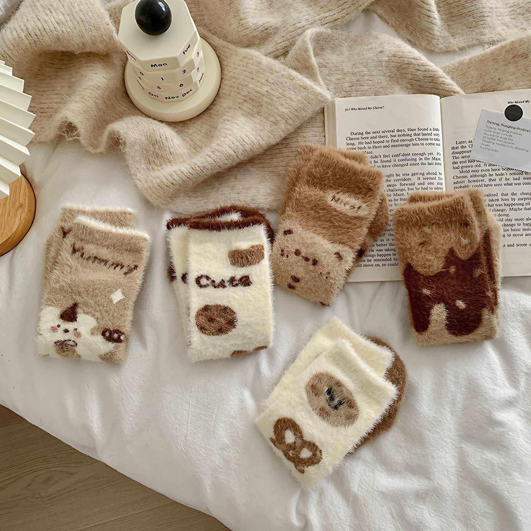 Assorted thermal plush socks displayed on a cozy bedding