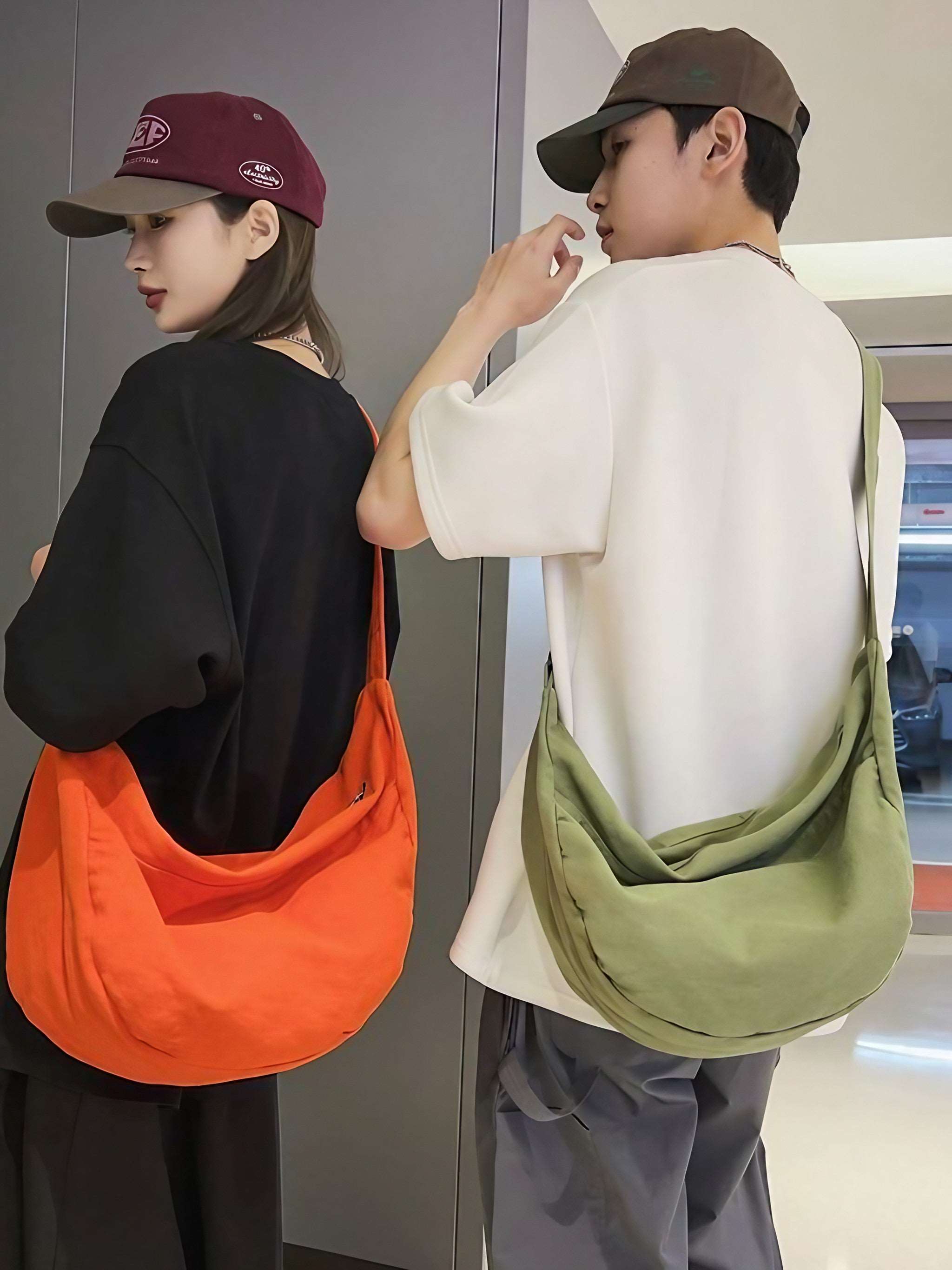 Two friends posing together, each sporting a hip canvas travel bag in orange and green