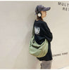 Music-loving woman outfitted with a green canvas crossbody bag