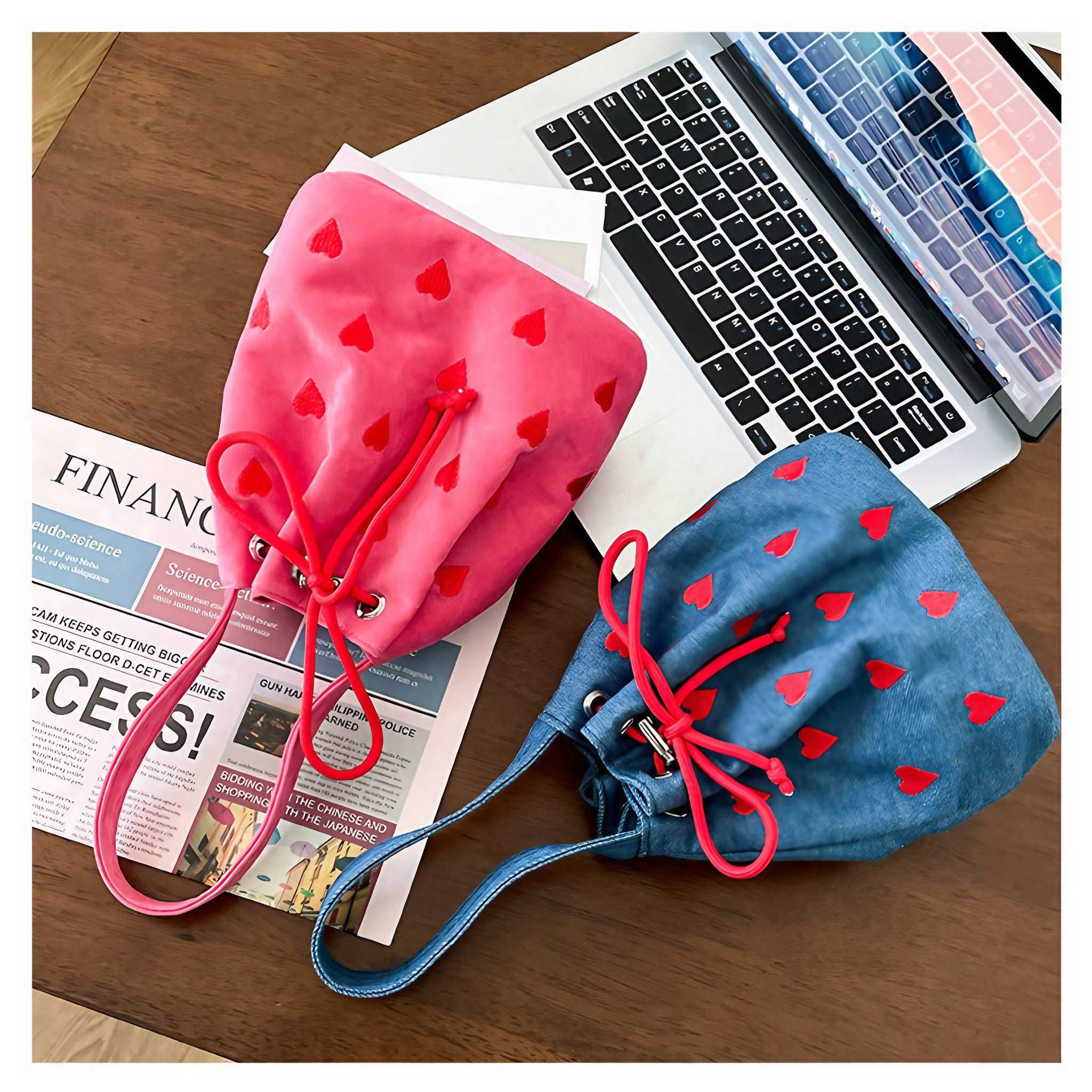 A pair of denim mini handbags with heart designs displayed on a desk