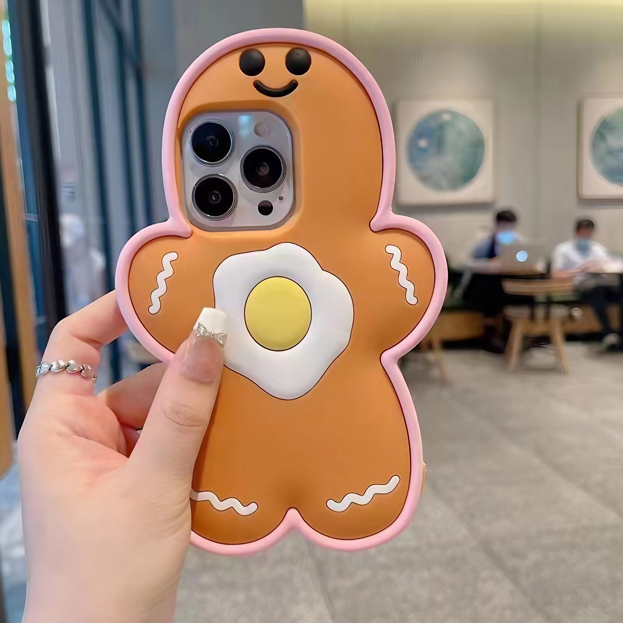 A hand holding a Christmas gingerbread man design on an iPhone case