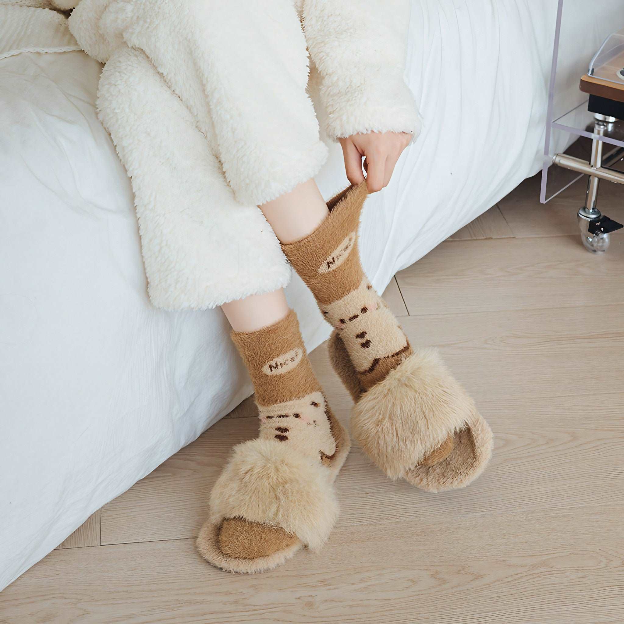 A woman lounging in a white robe with plush brown thermal socks