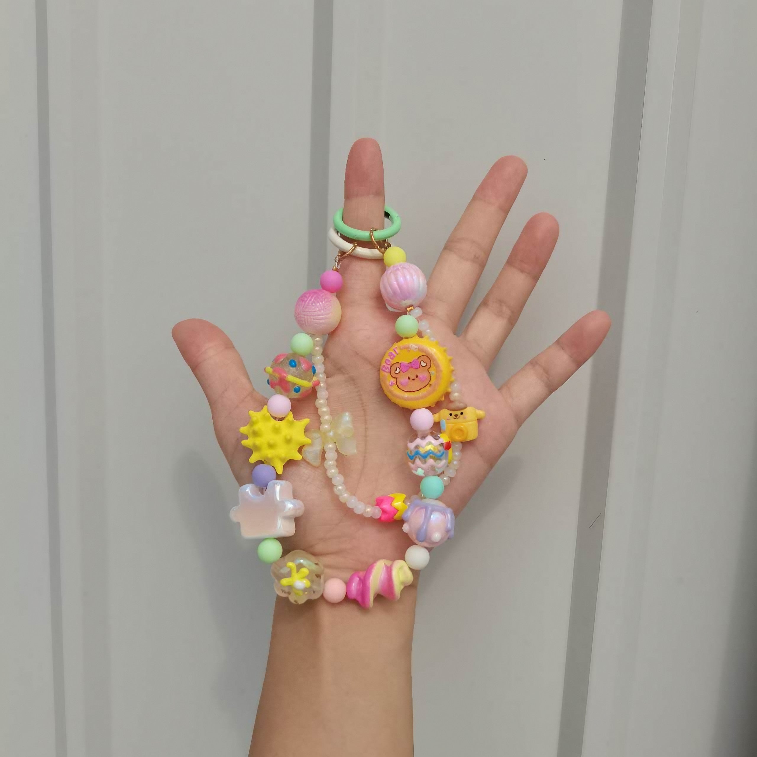 A hand showcasing a versatile fashion chain with pastel-colored beads for Y2K style accessories