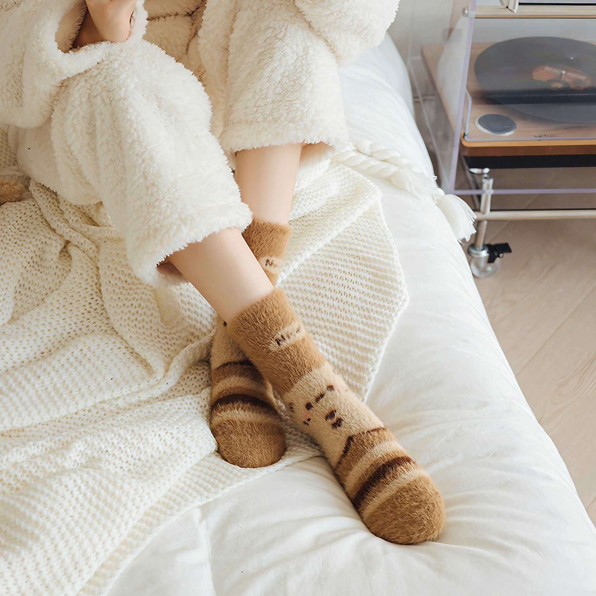 A woman enjoying the comfort of plush thermal socks in bed