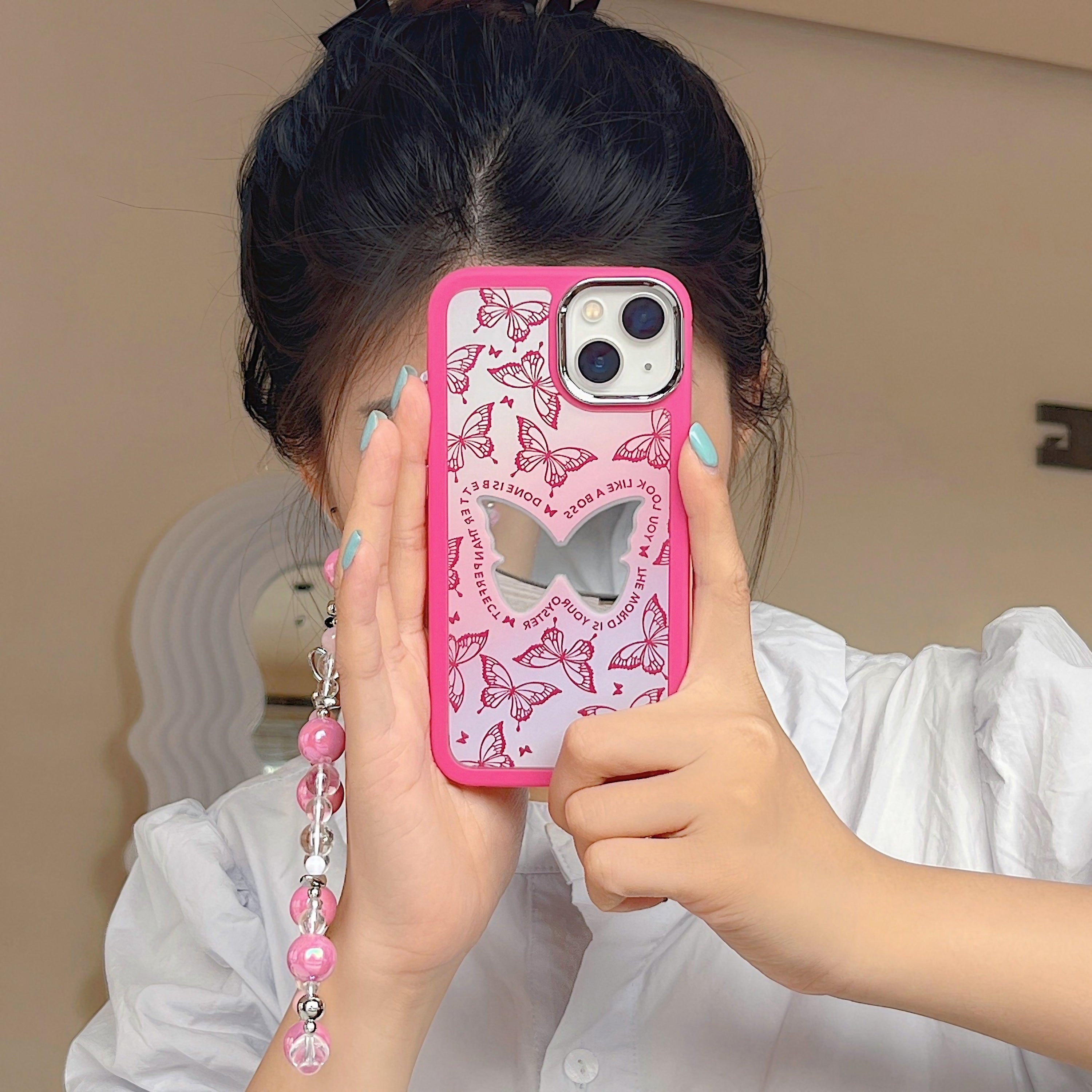 Female presenting a Gen Z style pink butterfly iPhone case with a phone chain